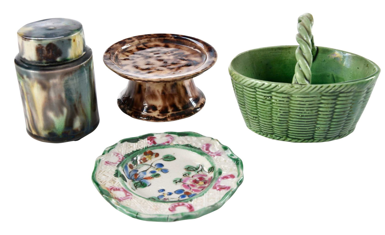 Four Miniature Staffordshire Pottery Objects: 18th century, comprising: Whieldon type footed stand; Whieldon type covered pill box; green glazed miniature basket; enamel decorated miniature plate; largest 2-1/4 x 5-1/8 x 1-7/8 in. Provenance: (st