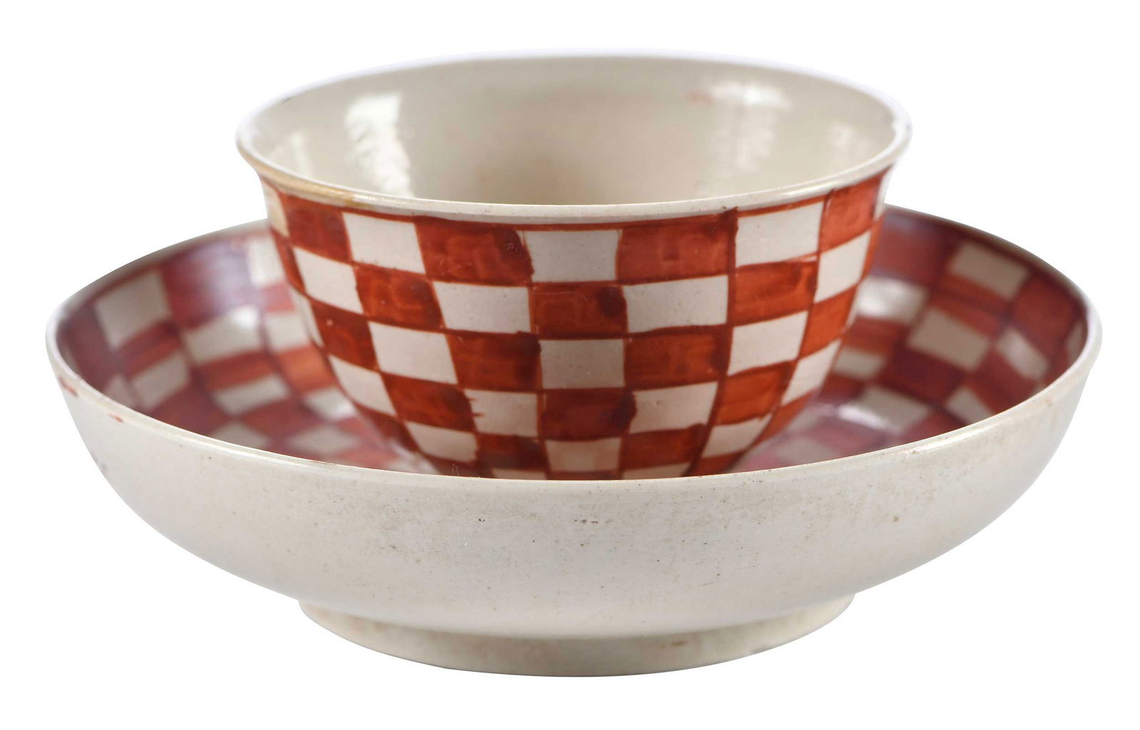 Staffordshire Salt Glazed Checkerboard Tea Bowl and Saucer: 18th century, bowl 1-1/2 x 2-5/8 x 2-5/8 in.; saucer 1 x 4-1/8 x 4-1/8 in. Provenance: Collection of Dr. Richard and Carol Lamb, Kennett Square, Pennsylvania