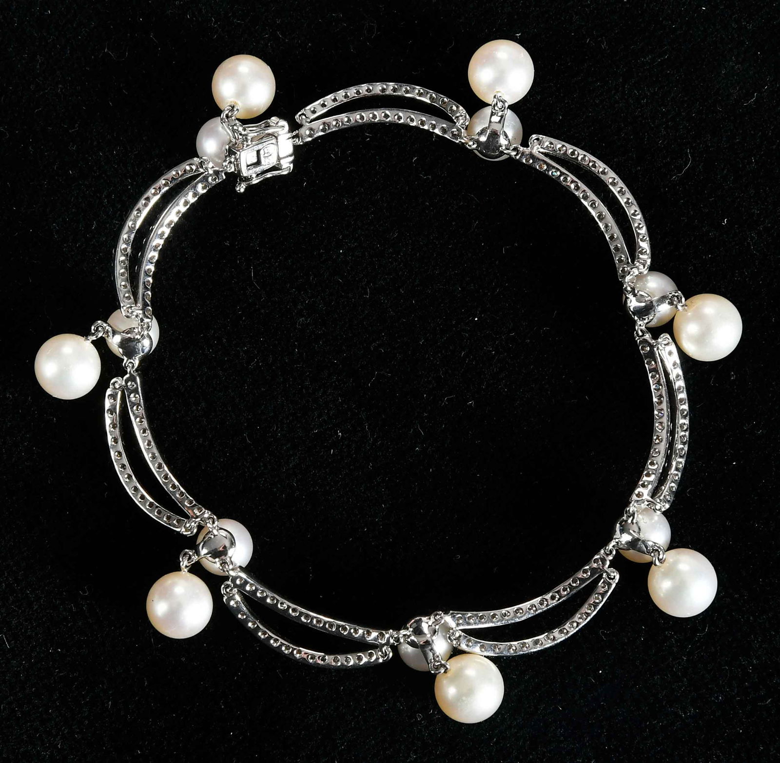 18kt. Scalloped Design Pearl and Diamond Bracelet: seven round white pearls, approx. 7.0-7.5mm, seven round white pearls, approx. 6.0 - 6.5mm, double links accented with round full cut diamonds, VS-SI, G-I, marked "ki, 750", white gold, 7 in. length,