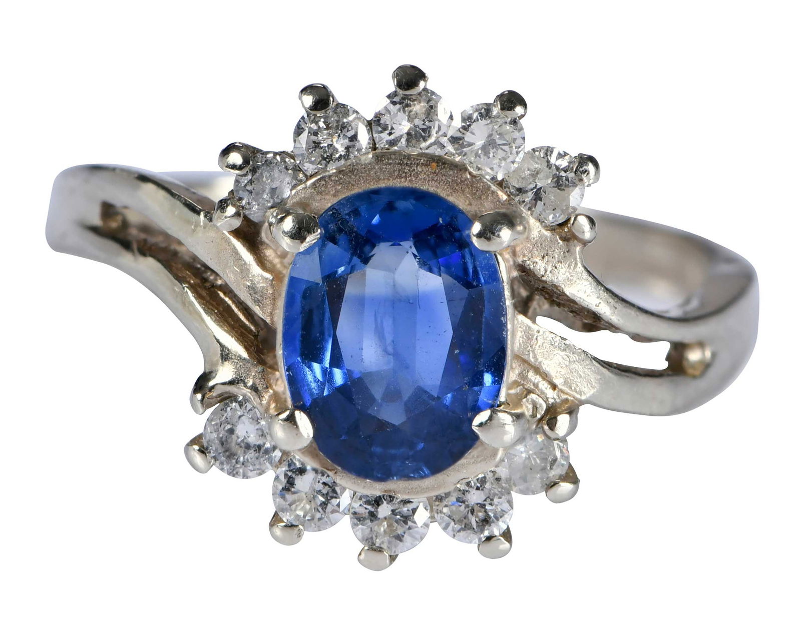 14kt. Blue Sapphire Bypass Diamond Ring: oval cut blue sapphire, approx. 0.90ct., 10 round full cut diamonds, marked "14K", white gold, 5-3/4 rings sz., 3.9 g Provenance: Estate of Linda Sargent Thompson, Historic Sesame Lodge, North Augusta