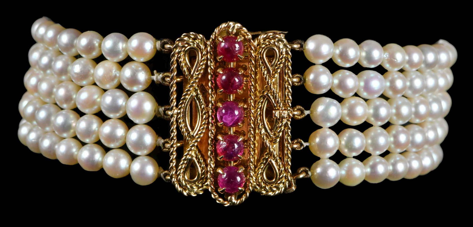 18kt. Multi Strand Pearl Bracelet with Ruby Clasp: five strands of graduating pearls, 3.0mm - 4.5mm, ornate open work clasp, five round cabochon rubies, tests 18kt. yellow gold, French gold marks, 7 in. length, clasp is 26mm wide, 29.4 gProvenance: