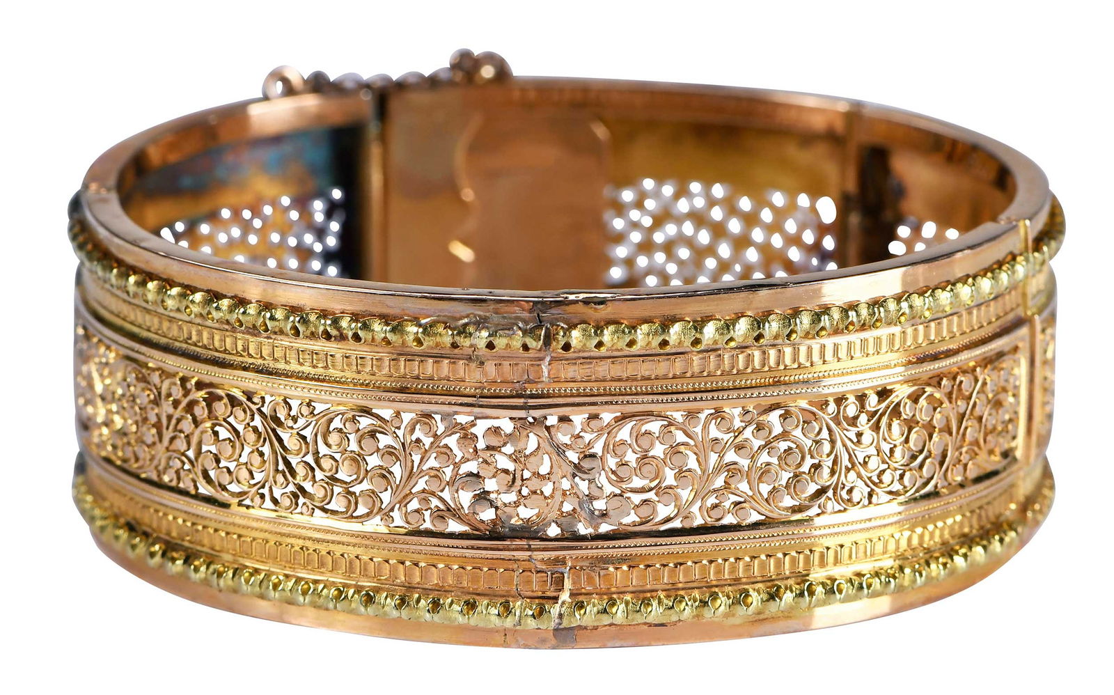 18kt. Open Work Hinged Bracelet: four wide panels, foliage design, tests 18kt. yellow gold and rose gold, 6-1/2 in. inside measurement, 22.0mm wide, 34.9 g Provenance: Private Asheville, North Carolina Collection Note: Brunk Auctions