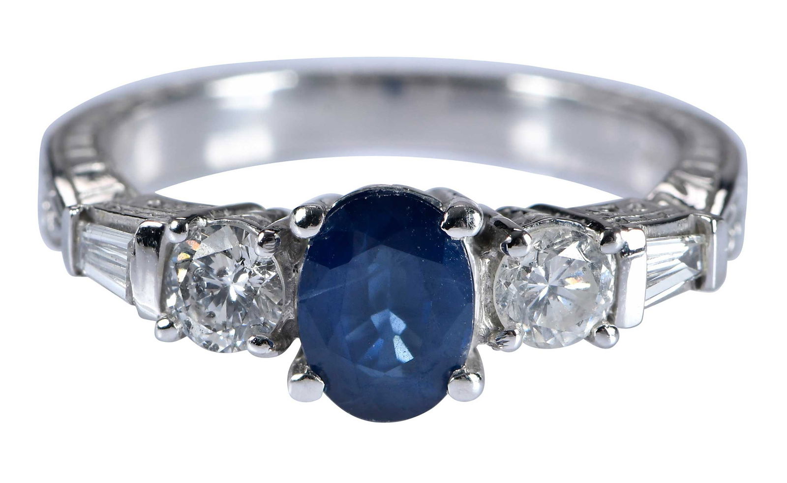14kt. Blue Sapphire and Diamond Engraved Ring: oval faceted blue sapphire, approx. 0.80ct., flanked by two round full cut diamonds, and two tapered baguette diamonds, approx. 0.50ctw., marked "14k, CID", 6-1/4 ring sz., 4.3 gProvenance: Private