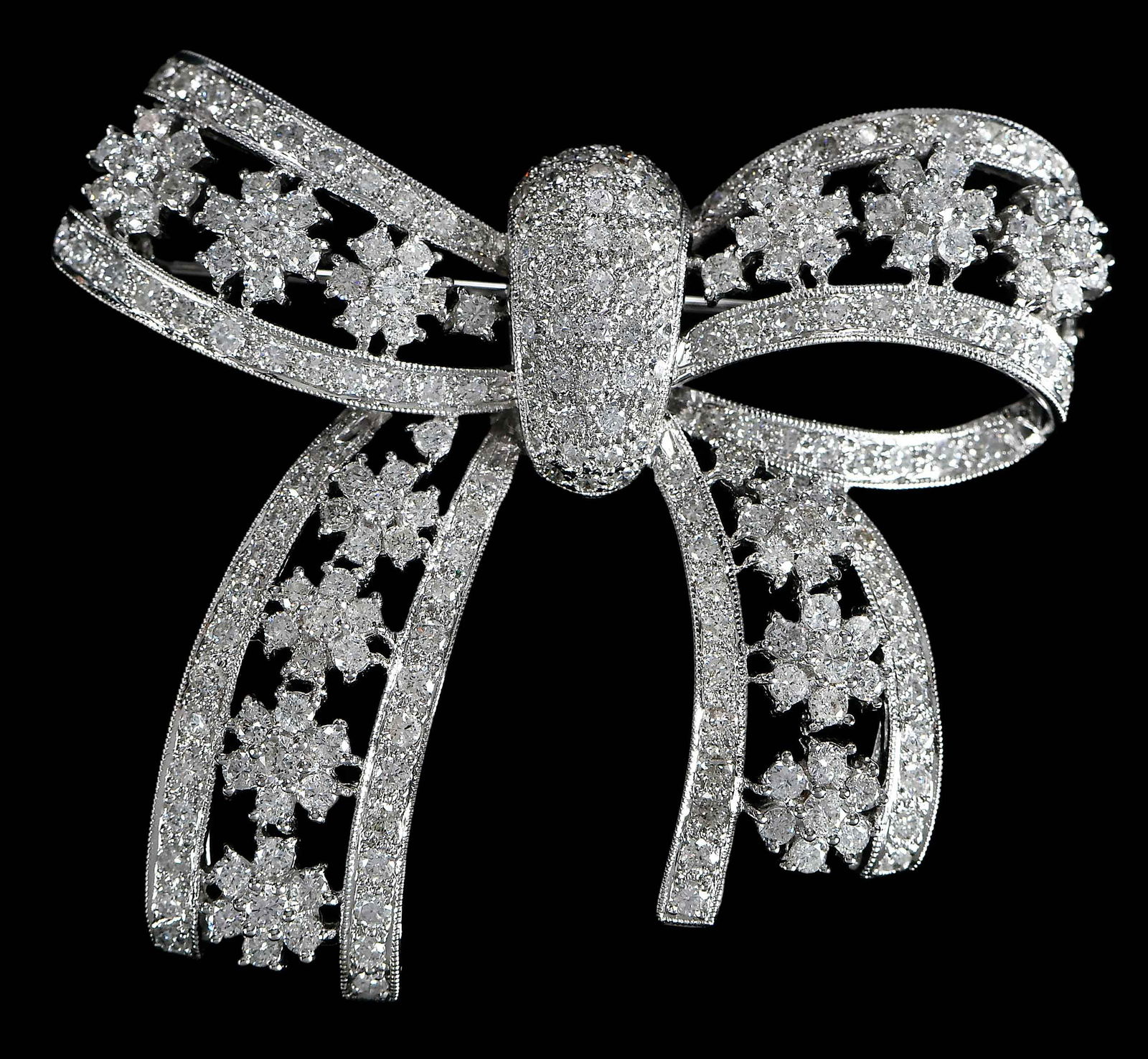 18kt. Diamond Open Work Bow Brooch: embellished with white round full cut diamonds, marked "18K, 750", white gold, 1-5/8 in. length, 2 in. at widest, 14.8 g Provenance: Private Collection Note: Brunk Auctions makes no warranty or guaran