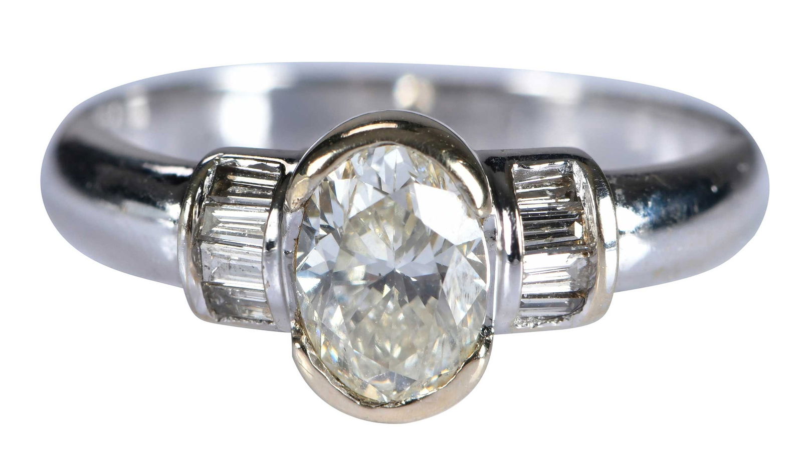 18kt. Semi Bezel Oval Diamond Ring with Diamond Accents: oval brilliant cut diamond, approx. 1.25ct., VS2-SI1, K-M, eight straight baguette cut diamonds, marked "18K", white gold and yellow gold semi bezel, 6-1/4 ring sz., 4.6 g Provenance: Estate of Linda