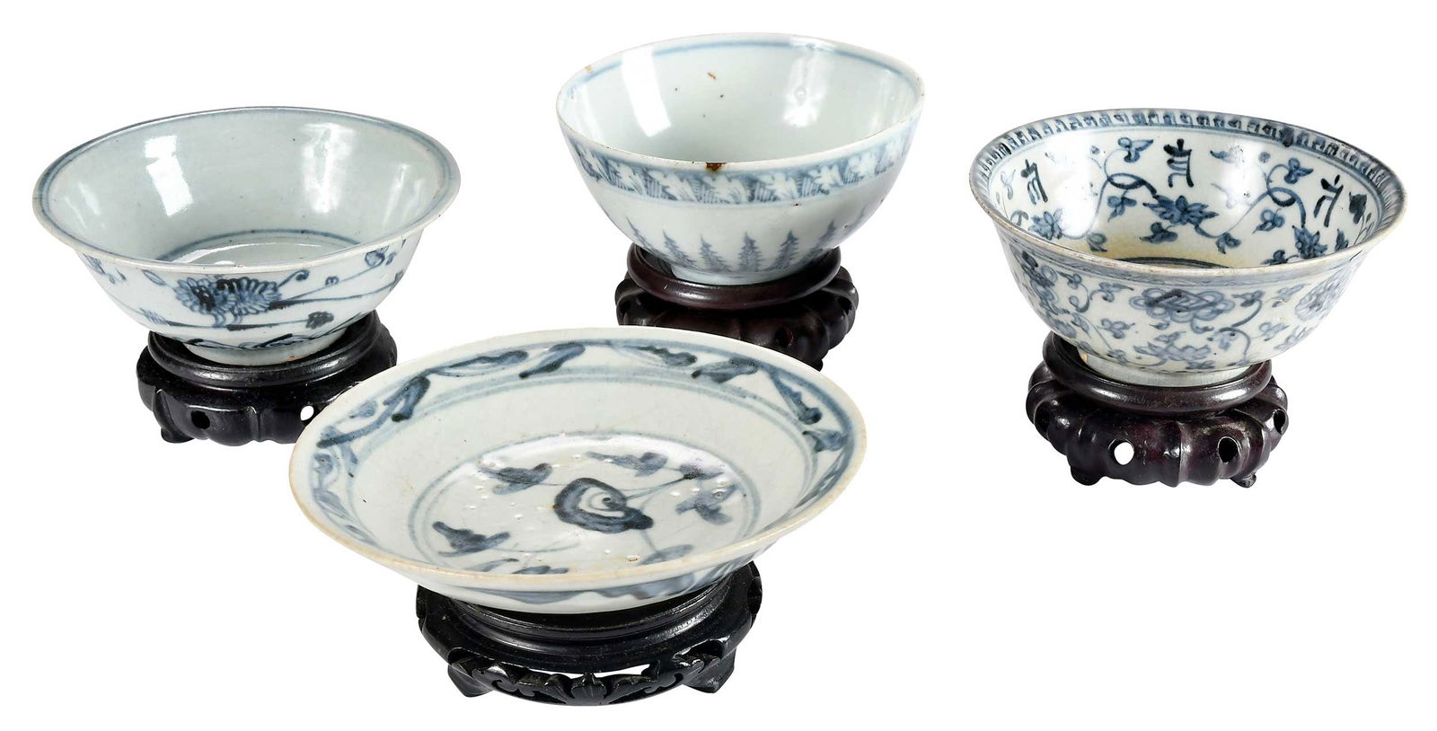 Four Chinese Blue and White Bowls: possibly Ming dynasty, largest 2-7/8 x 5-1/2 x 5-1/2 in; with four carved wood stands, largest 1-1/2 x 4-1/4 x 4-1/4 in. Provenance: Private Virginia Collection