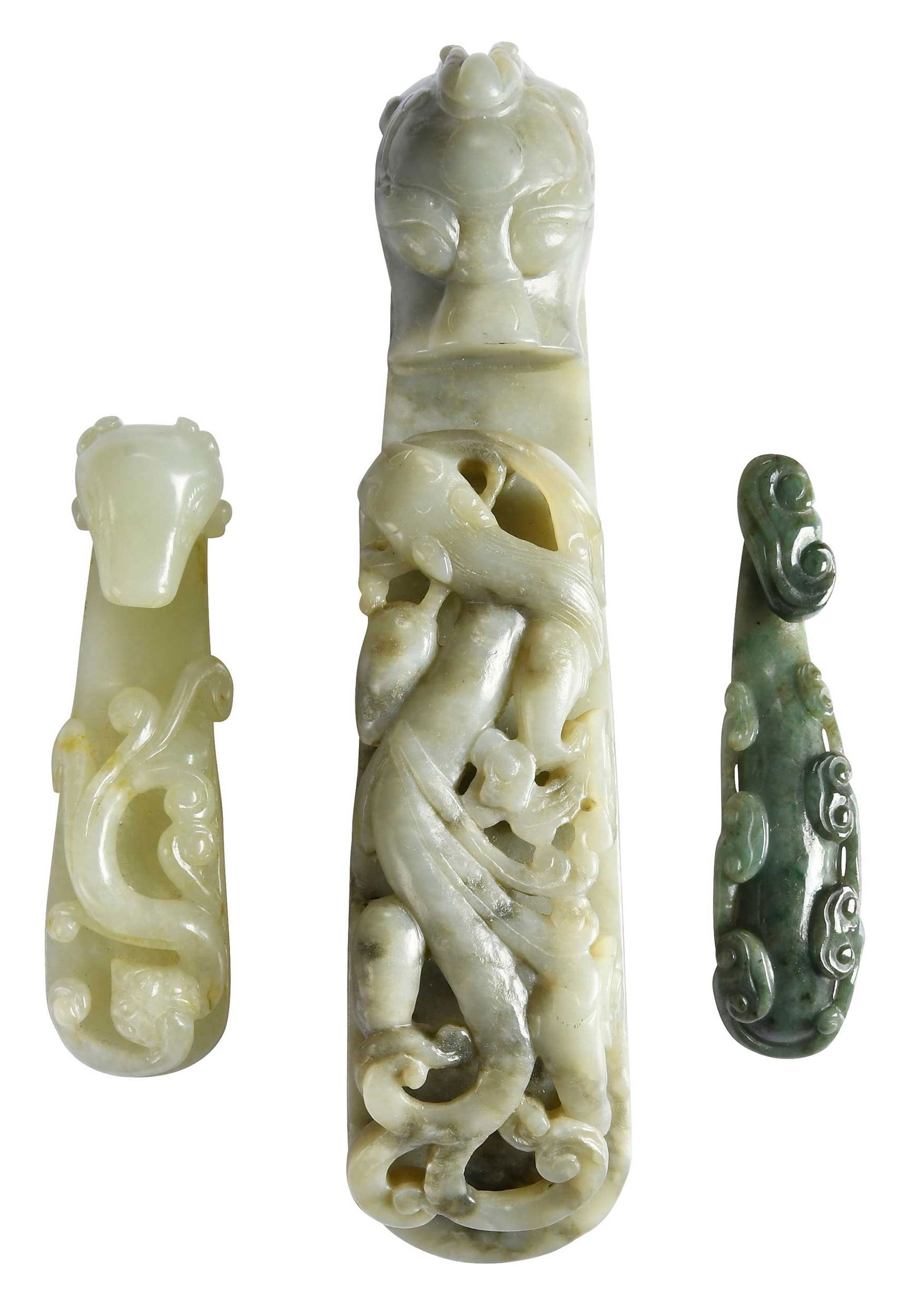 Three Jade Belt Buckles: one light green with black inclusions, one celadon, and one spinach green, largest 1-3/8 x 6-1/8 x 1-1/2 in. Note: The largest and smallest object tests as jadeite, and the middle as nephrite, on the