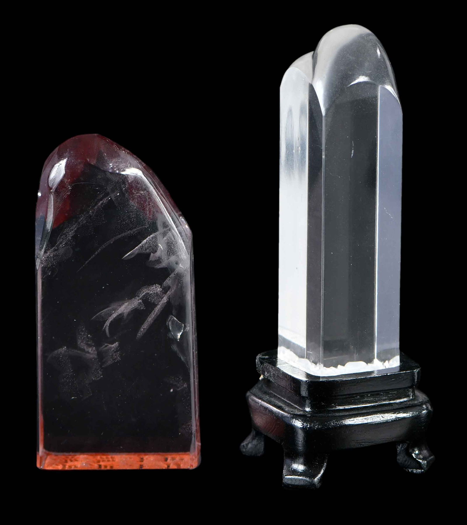 Two Chinese Carved Boulder Form Quartz Seals: comprising: smoky quartz example, 3 x 1-1/4 x 5/8 in.; clear quartz example, 3 x 3/4 x 5/8 in., with conforming wood stand, height on stand 3-7/8 in.Provenance: The Lifetime Collection of Ronald