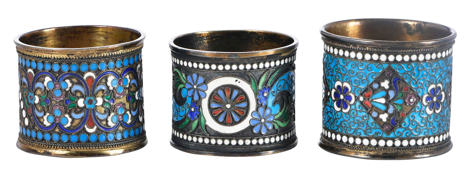 Three Silver and Enamel Napkin Rings: late 19th/early 20th century, all with blue, green and red floral and scroll decoration, gilt silver: two with Latvia and/or Russian marks .875 fine; one unmarked, 1-3/8 in. to 1-5/8 in.Provenance: