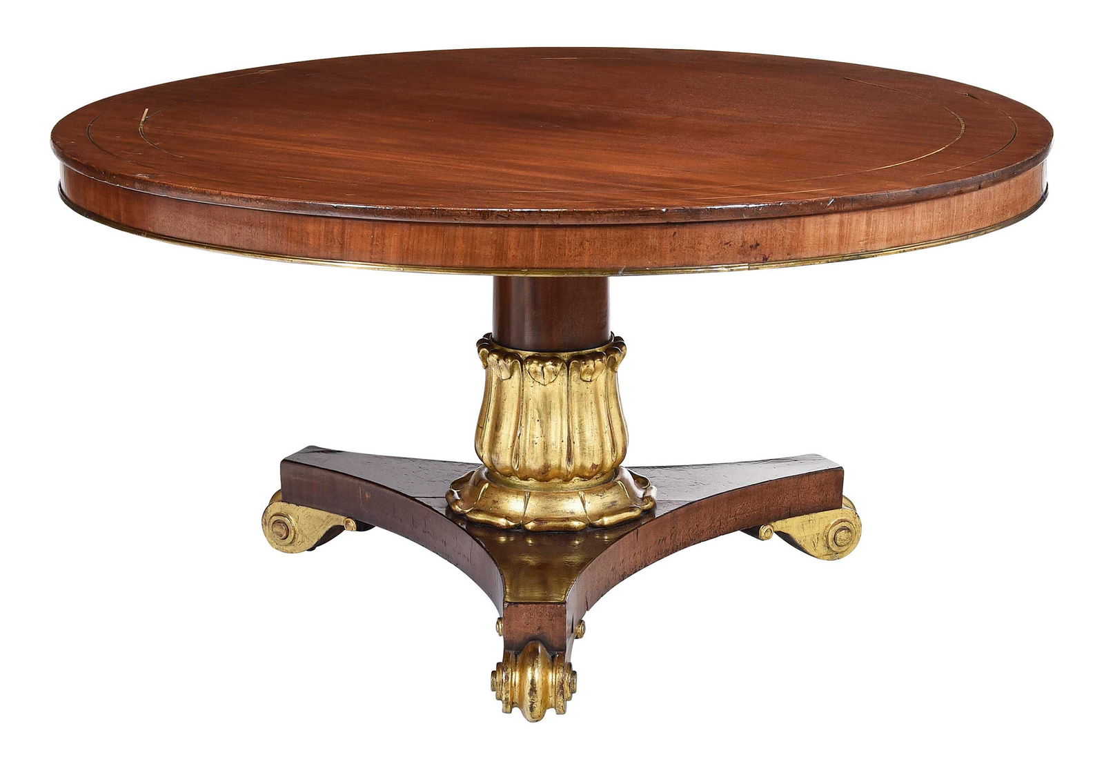 Regency Style Parcel Gilt Brass Inlaid Mahogany Center Table: late 19th century, brass inlaid and mounted tilt top, tripod pedestal base with bold giltwood carvings, 29 x 54 x 54 in. Provenance: Property from a Private Collection, Vero Beach, Florida