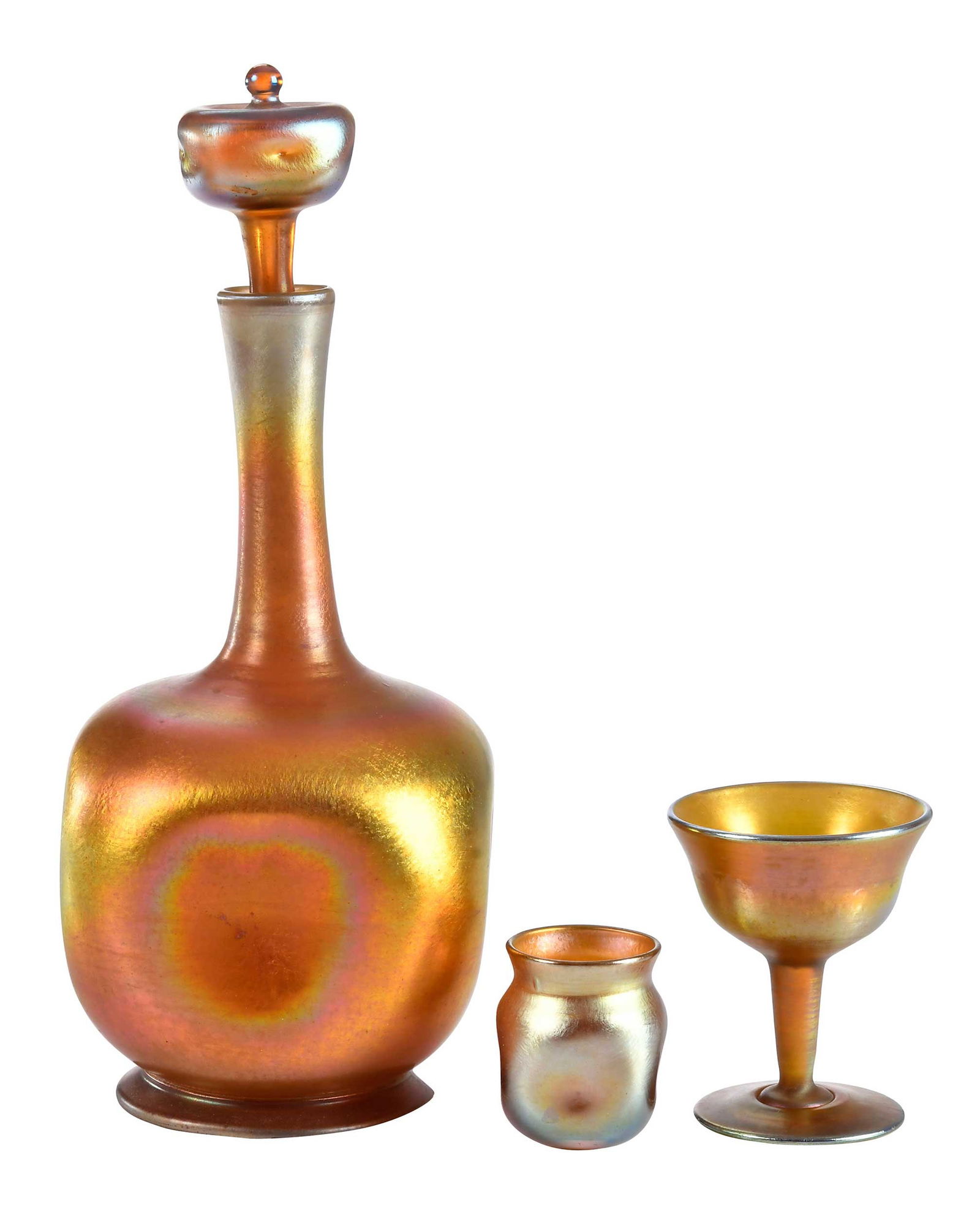 Three Pieces of Tiffany Favrile Glass Drinkware: 20th century, each etched "L.C.T." at undersides of bases, comprising: decanter with "73" etched at underside of base and stopper; diminutive goblet with "Favrile" etched at underside of base;