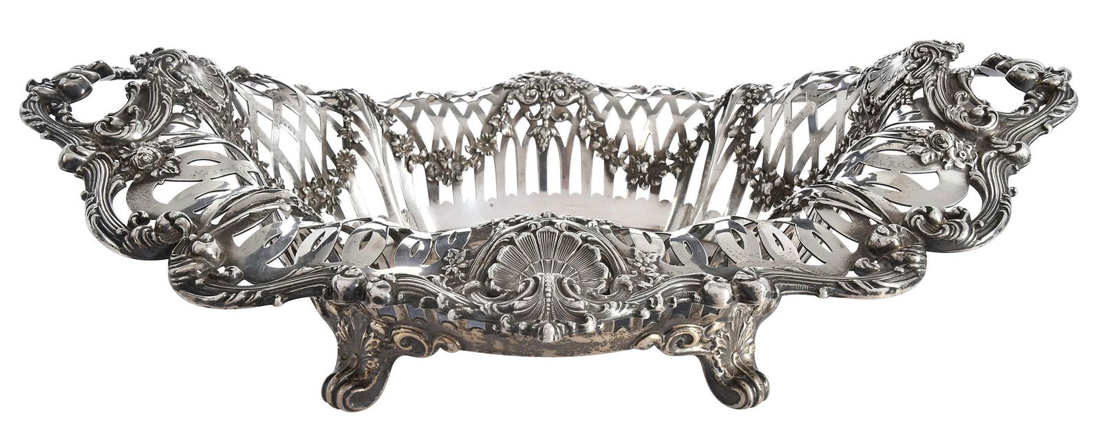 Ornate Openwork Sterling Two Handle Center Bowl: American, 20th century, oval with openwork sides, shell, floral, and swag decoration, two handles, central monogram, marks for retailer Cowell & Hubbard, 48.03 oz. T., 5-1/4 x 16-1/2 x 13-1/2