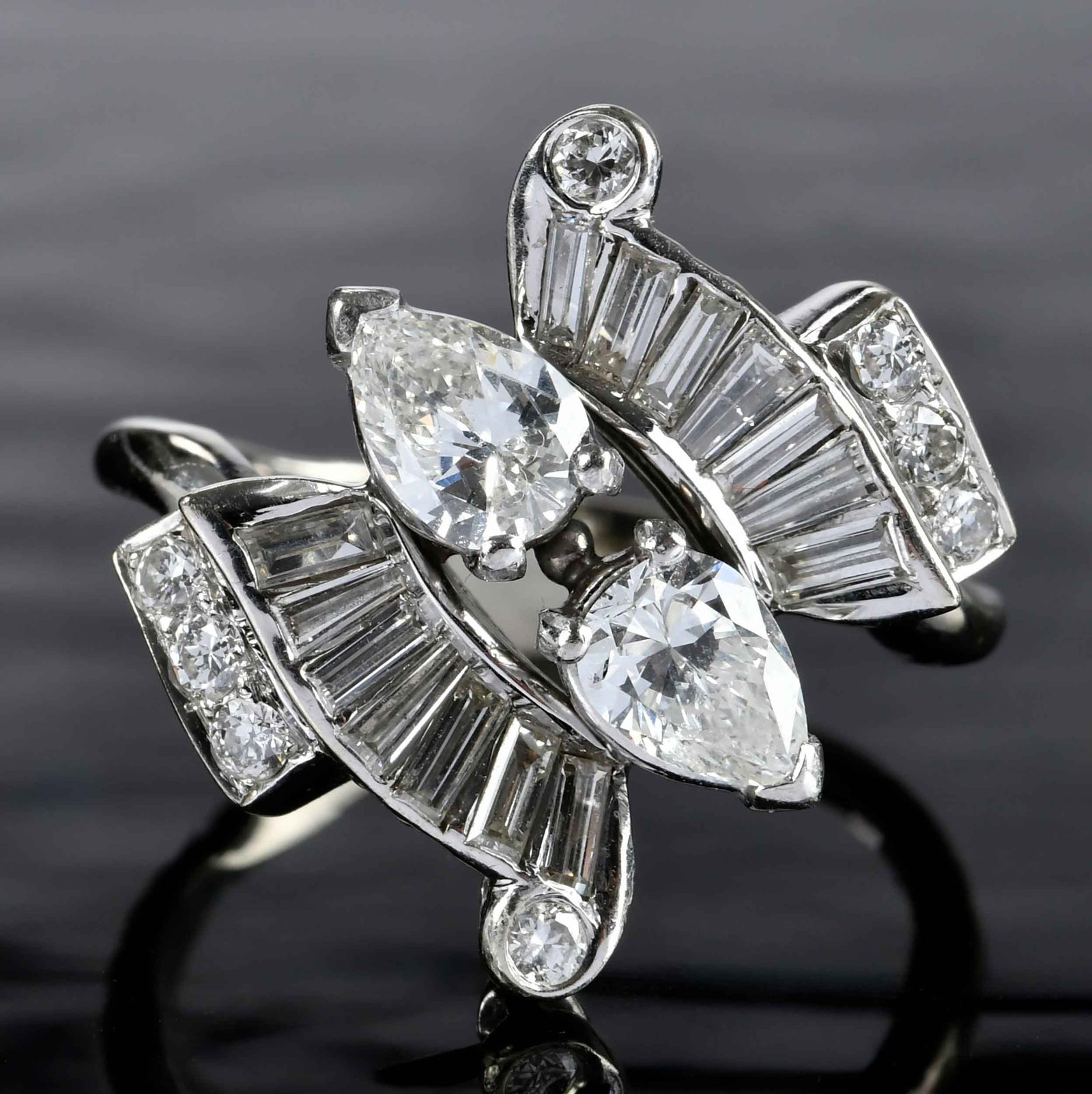 14kt. Vintage By Pass Diamond and Ruby Ring: two pear shape faceted cut diamonds, approx. 0.80ctw., VS, H-I, eight transitional cut diamonds, 14 straight and tapered baguette cut diamonds, approx. 0.75ctw., tests 14K white gold, 8-1/2 ring sz., 
