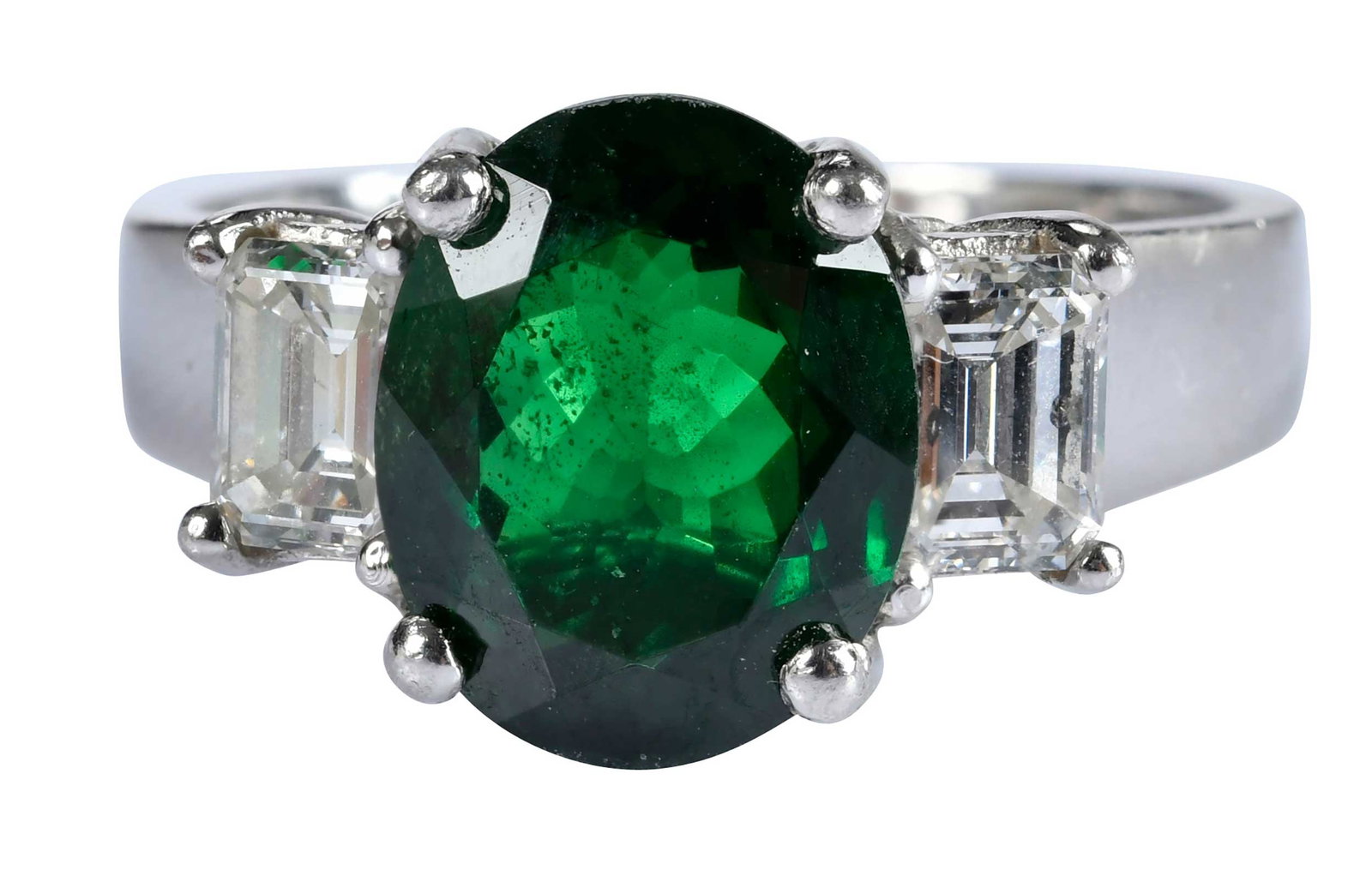 Platinum Three Stone Tsavorite Garnet and Diamond Ring: modified oval cut tsavorite garnet, approx. 4.10ct., flanked by two emerald cut diamonds, approx. 1.15ctw., SI, F-G, marked "PLAT 950", 9 ring sz., 10.7 g Provenance: Private Collection, Virginia Beac