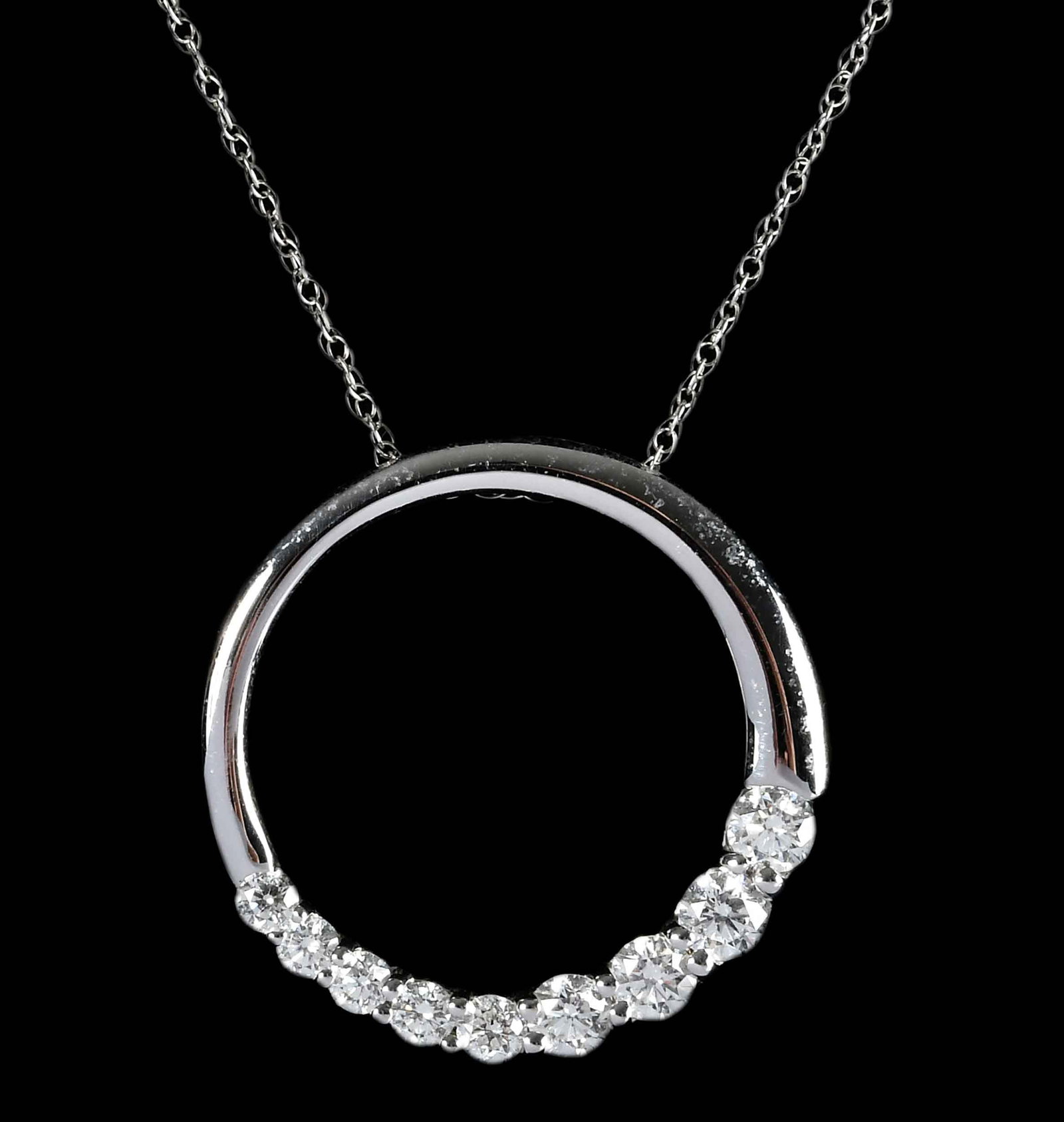 14kt. Eternity Diamond Pendant: nine round faceted diamonds, graduating in size, approx. 1.00ctw., VS, F-H, marked "14k, R", white gold, 1 in. diameter, wheat chain, marked "14K", white gold, 158 in. length, 4.4 g Provenance: Privat