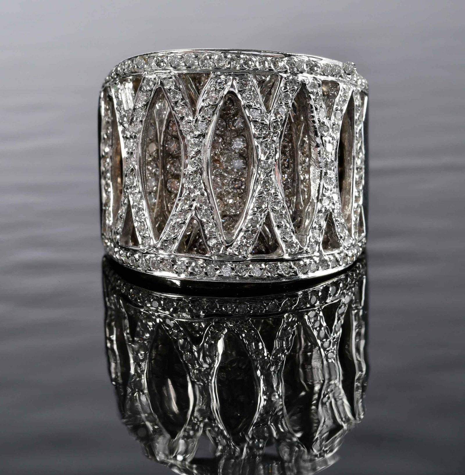 14kt. Double Layered Diamond Band: top layer: round faceted diamonds; lower layer: light champagne round faceted diamonds, approx. 1.50ctw., marked "14k", white gold,10 ring sz., 20.0mm width at widest, 22.7 g Provenance: Private Colle