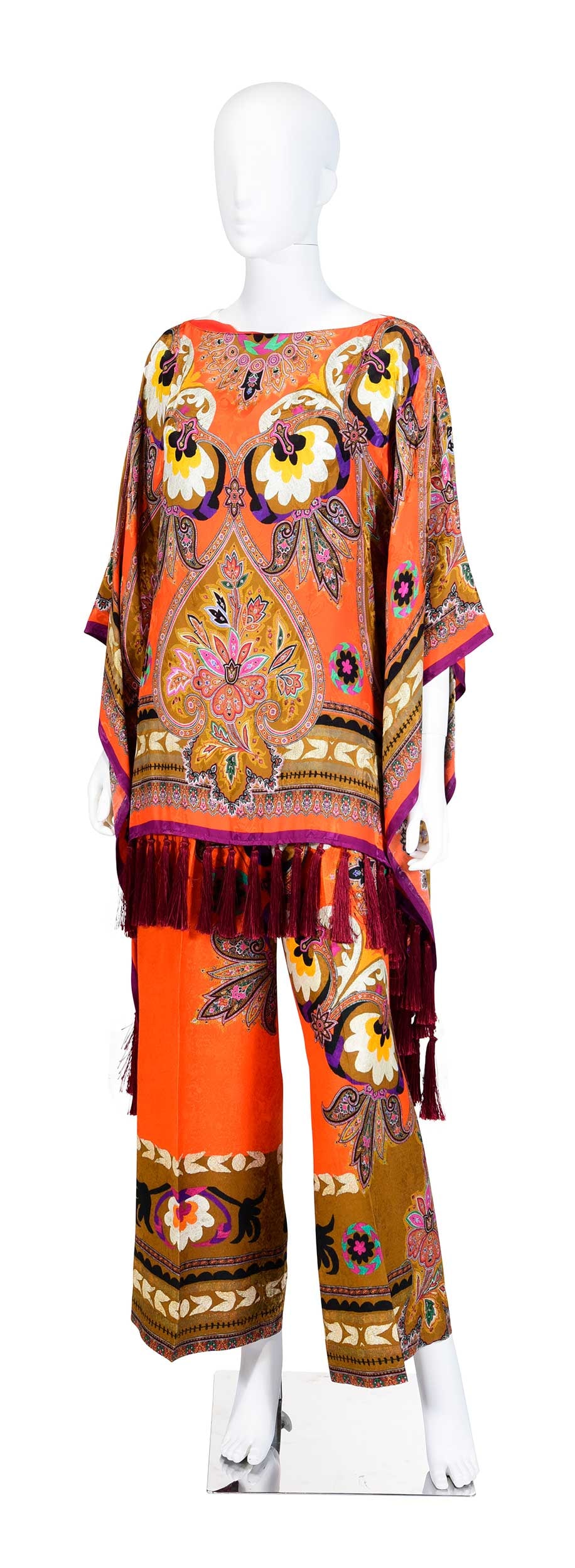 Etro Orange Paisley Print Ensemble: Italy, poncho, shoulder approx. 14-1/4 in., length 31-1/2 in. with tassels; pants, tagged size "46", waist 31 in., inseam 27 in. Provenance: Private Collection, Highlands, North Carolina