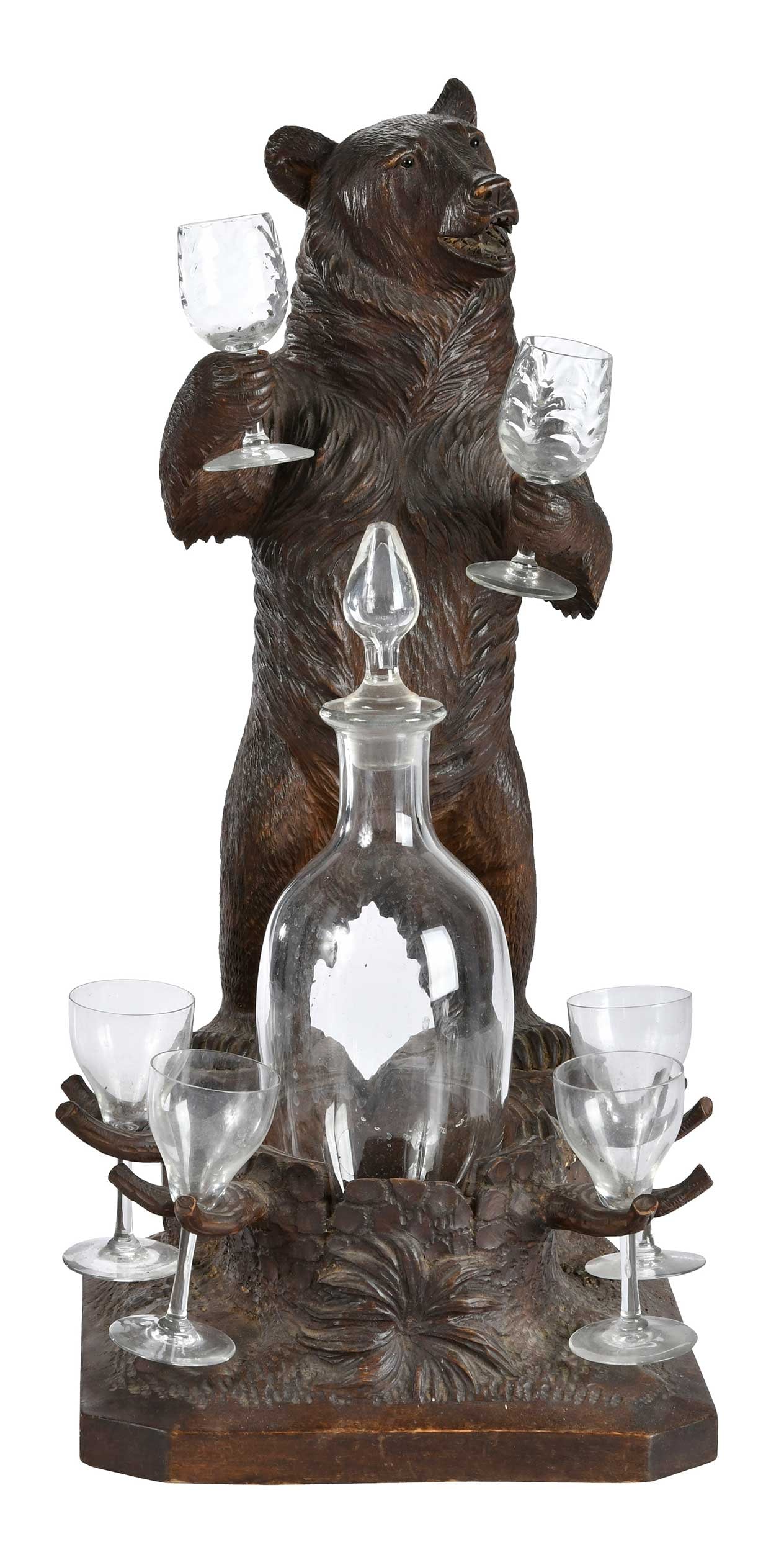 Black Forest Carved Bear Figural Musical Drink Stand: German, 20th century, finely carved upright bear with paws positioned to hold cordials, central recess for decanter with push down start/stop mechanism, winder mechanism to underside of base, with sto