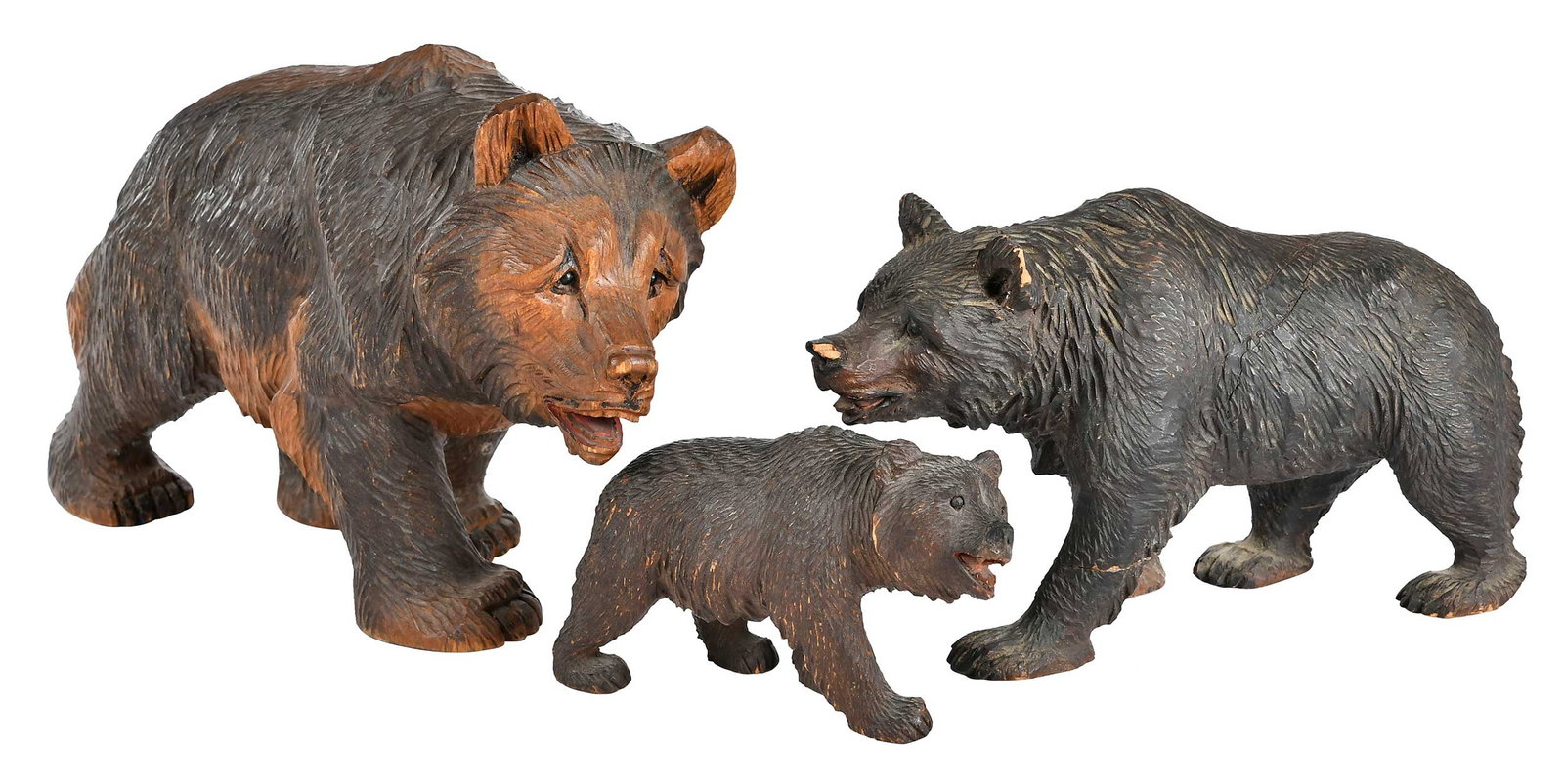 Three Black Forest Carved Bears Figurines: German, late 19th/20th century, each with inset glass eyes, two with painted mouths, largest 6-5/8 x 3-1/4 x 10-1/4 in. Provenance: Collection of Steve Stewart, Lake Lure, North Carolina