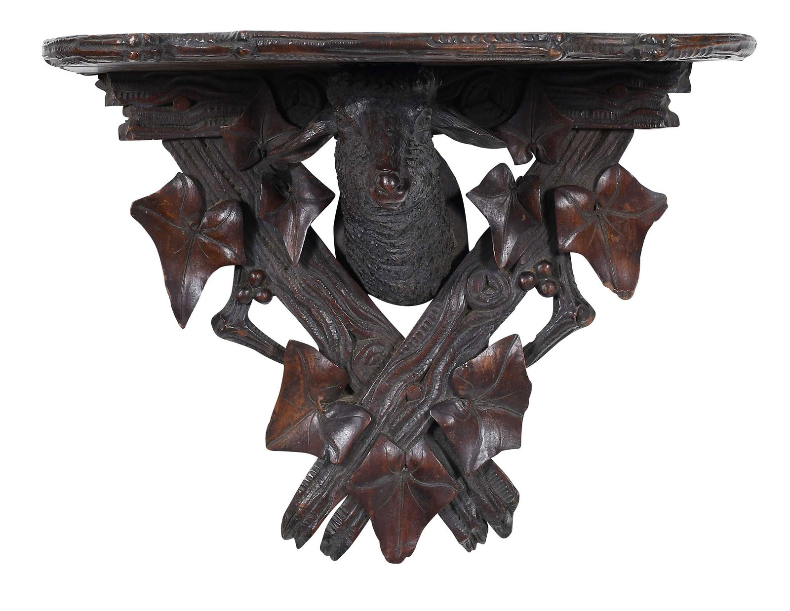Black Forest Lamb's Head Wall Bracket: Swiss, 19th century, D-shaped shelf over lamb's head mount with carved berries, ivy leaves, and boards, 13-1/8 x 15-3/4 x 8-3/4 in. Provenance: Byerly's Antiques, Greensboro, North Carolina (labels);
