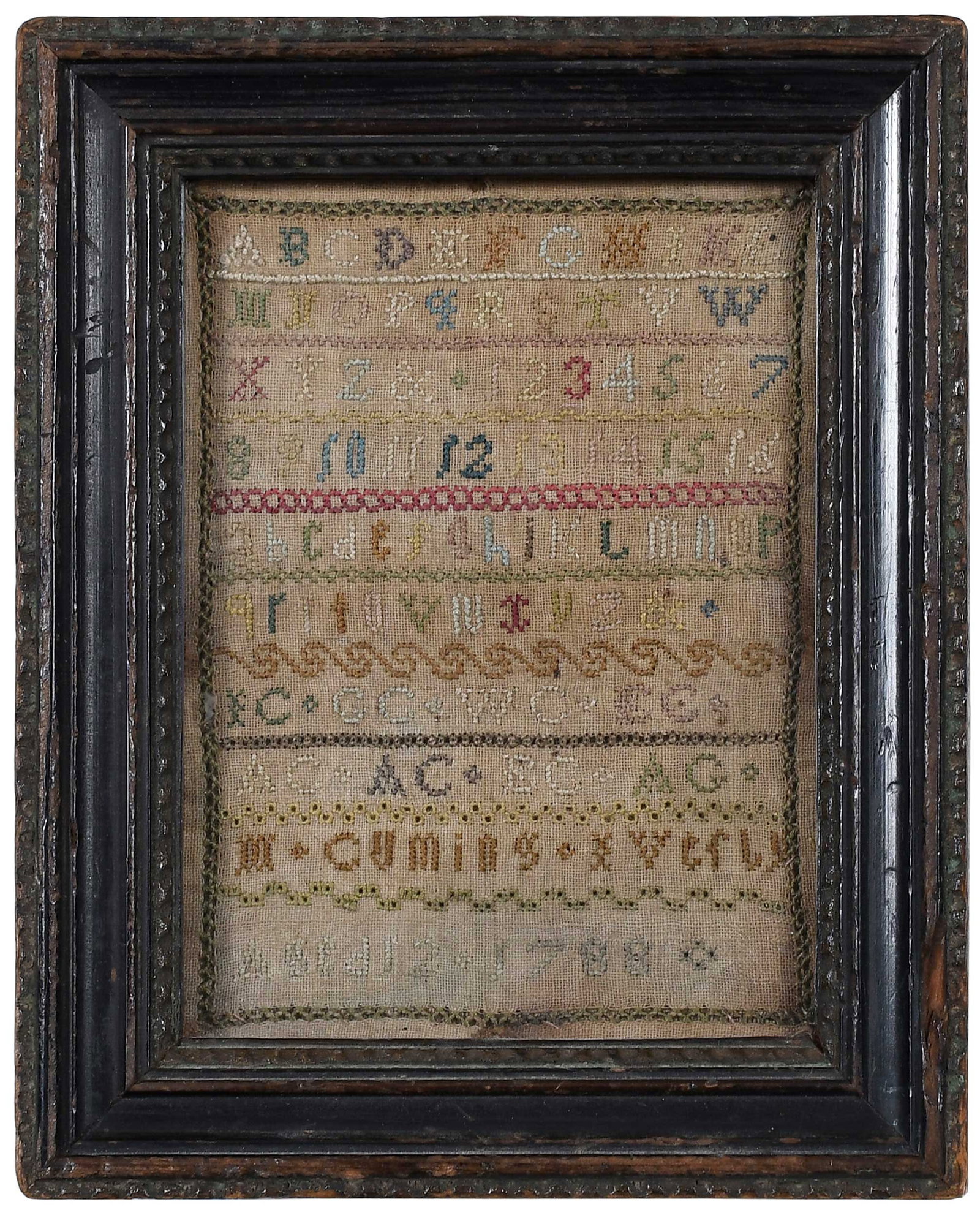 Framed Signed and Dated 1788 Miniature Alphabet Sampler: signed "M. Cuming" and dated "1788", with list of initials (likely of family members), sight 5-1/2 x 3-1/4 in.; carved and painted wood frame, 6-1/4 x 5 x 7/8 in. Provenance: M. Finkel & Daughter, Phi