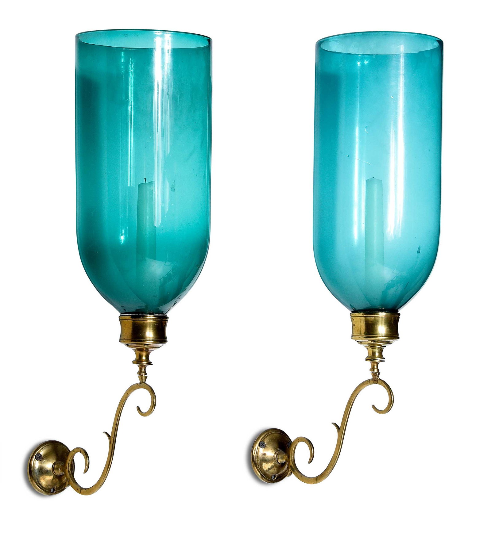 Pair Turquoise Glass and Brass Hurricane Wall Sconces: each scrolled brass arm with candle cup, supporting straight cylindrical blue-green glass shade, with candles and hardware, each approximately 20 x 10 x 5-3/4 in. Provenance: Mr. and Mrs. Jerome W. Bl
