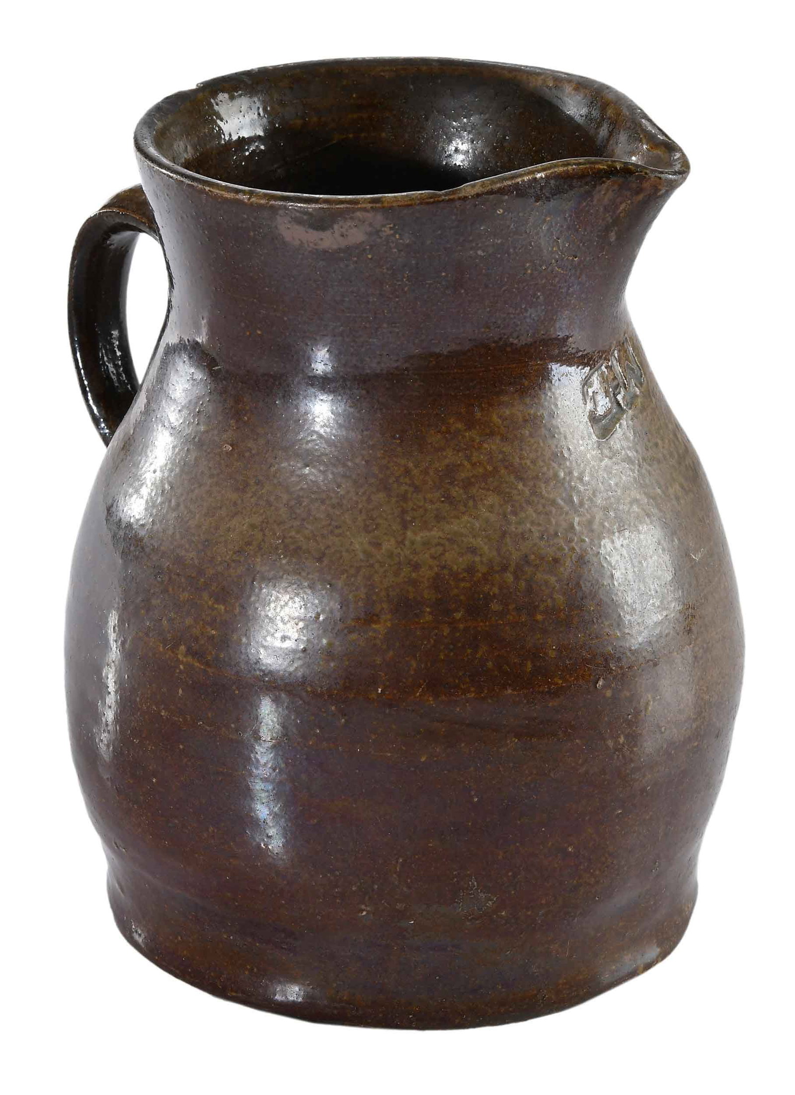 Rare Alabama Attributed "GW" Stamped Stoneware Pitcher: possibly made by George Washington Boyd, Rock Mills, Alabama, circa 1875, salt and Albany slip alkaline glaze, stamped "GW" under spout, wide lower body, flared rim, applied strap handle, 9 in. Proven