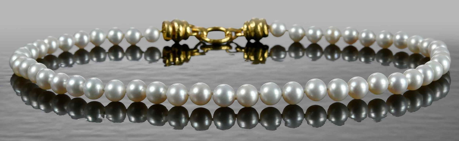 19kt. Elizabeth Locke "Martin" Clasp Fresh Water Pearl Necklace: single strand, 8.5 - 9.0mm, marked "19K", yellow gold, maker's mark, hidden clasp, 17 in. length, 54.0 g Provenance: Collection of Dr. George and Connie Manger Note: Brunk Auctions makes no warranty o
