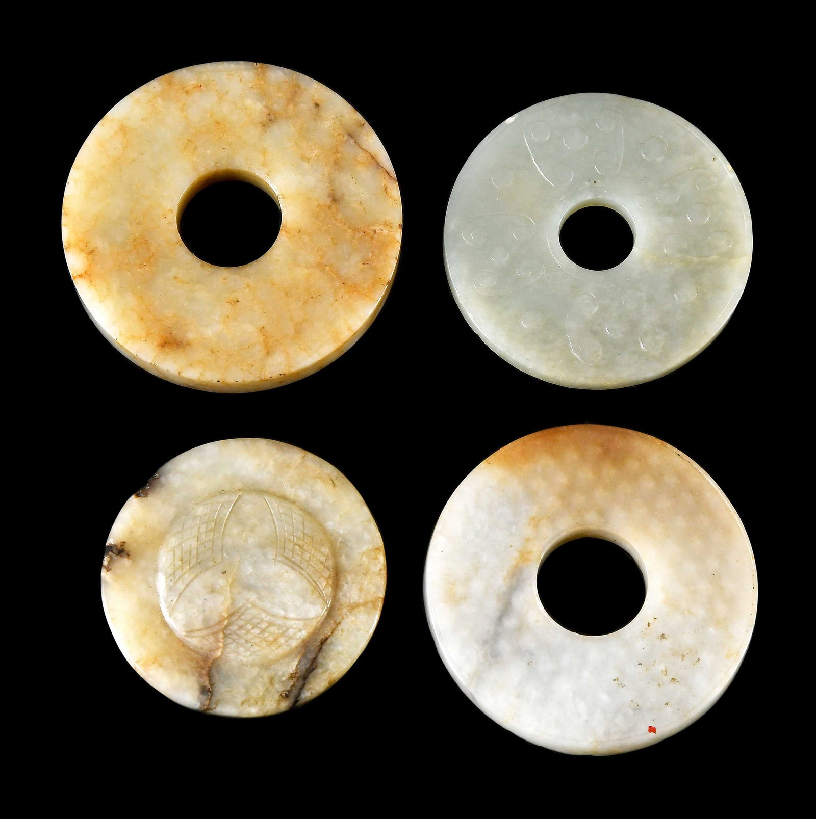 Four Small Chinese Carved Jade Bi Disks: three with engraved decoration, some with russet and dark inclusions, largest 1/4 x 2-3/8 x 2-3/8 in. Provenance: The Collection of William S. Arnett, Atlanta, Georgia; sold to benefit Tinwood Foundat