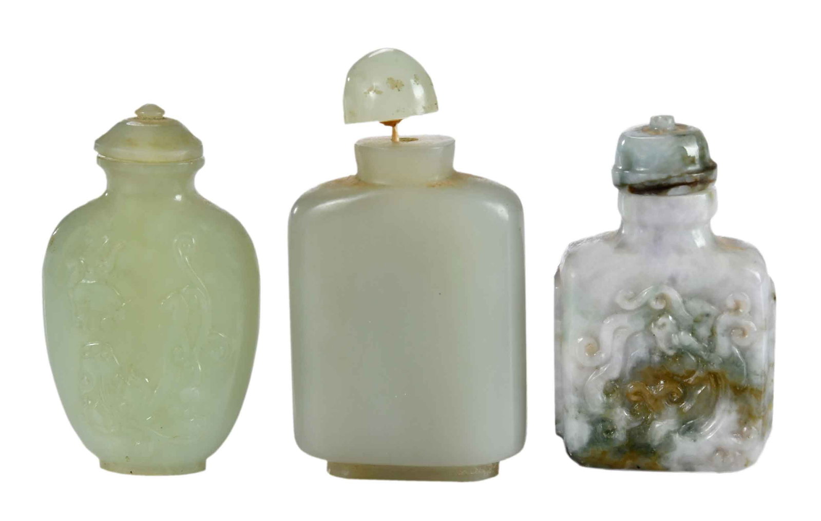 Three Chinese Carved Jade Snuff Bottles: two with carved dragon decoration, each with jade cap and bone or wood spoon, largest 3-1/4 x 1-3/4 x 3/4 in. Provenance: Collection of Dr. George and Connie Manger Note: These items test as nephrite 