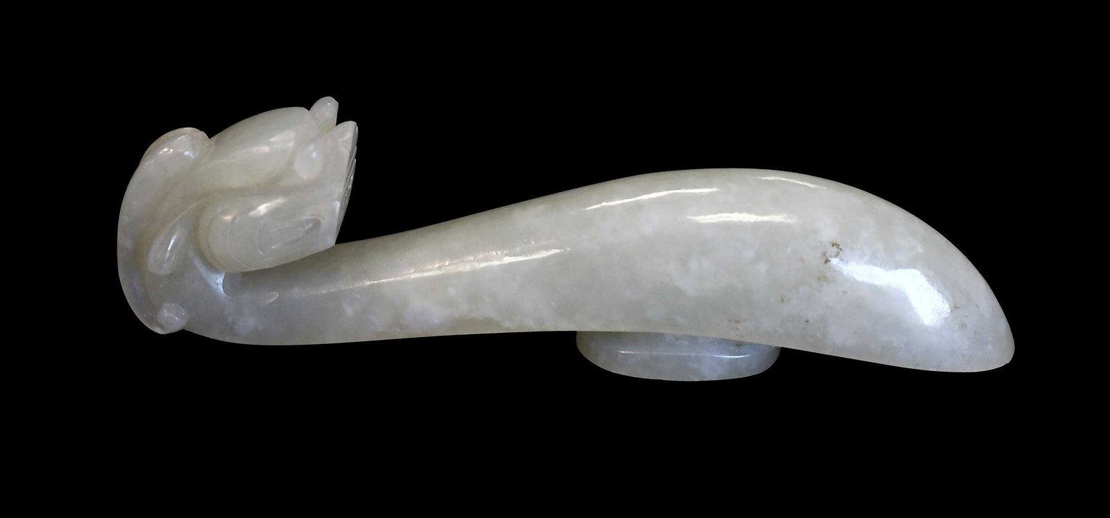 Chinese Carved Jade Belt Hook: qiulong (horned dragon) head motif in mottled pale green jade with small brown inclusions, 3-1/2 x 5/8 x 3/4 in. Provenance: The Collection of William S. Arnett, Atlanta, Georgia; sold to benefit Tinw