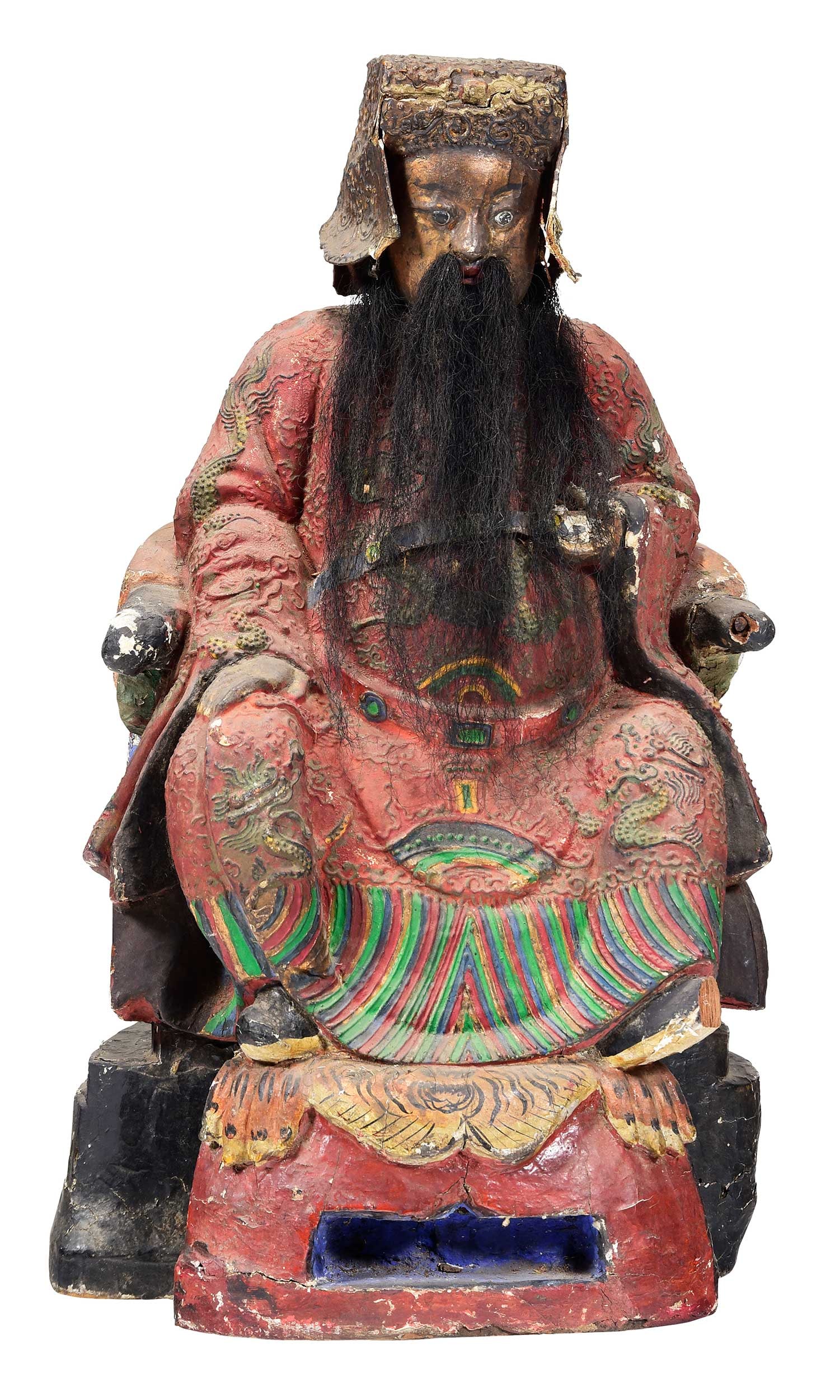 Large Carved and Polychromed Seated Guardian Figure: Chinese/Tibetan, 18th/19th century, possibly a Dharmapala statue depicting the Heavenly King Vaisravana enthroned, seated atop a tiger pelt in multicolored robes, carved wood, paper, and hair construc