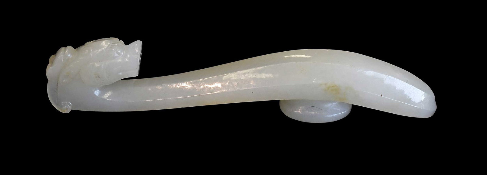 Chinese Carved Jade Chilong Belt Hook: pale green with yellowish inclusions, 4-3/4 x 5/8 x 1 in. Provenance: The Collection of William S. Arnett, Atlanta, Georgia; sold to benefit Tinwood Foundation Note: This item tested as nephrite on