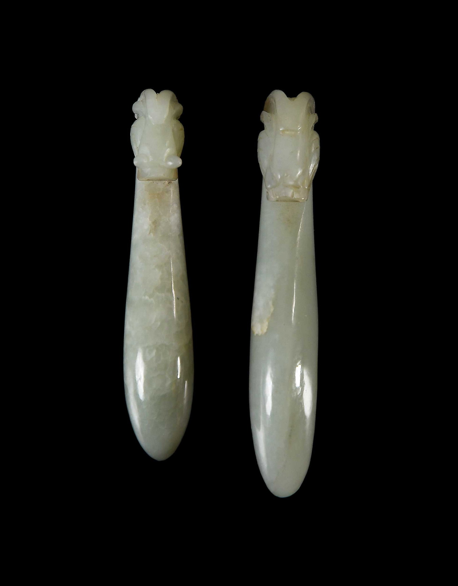 Two Chinese Carved Pale Green Jade Belt Hooks: with carved dragon/chilong heads, larger 3-5/8 x 5/8 x 1 in. Provenance: The Collection of William S. Arnett, Atlanta, Georgia; sold to benefit Tinwood Foundation Note: These items test as nephrite