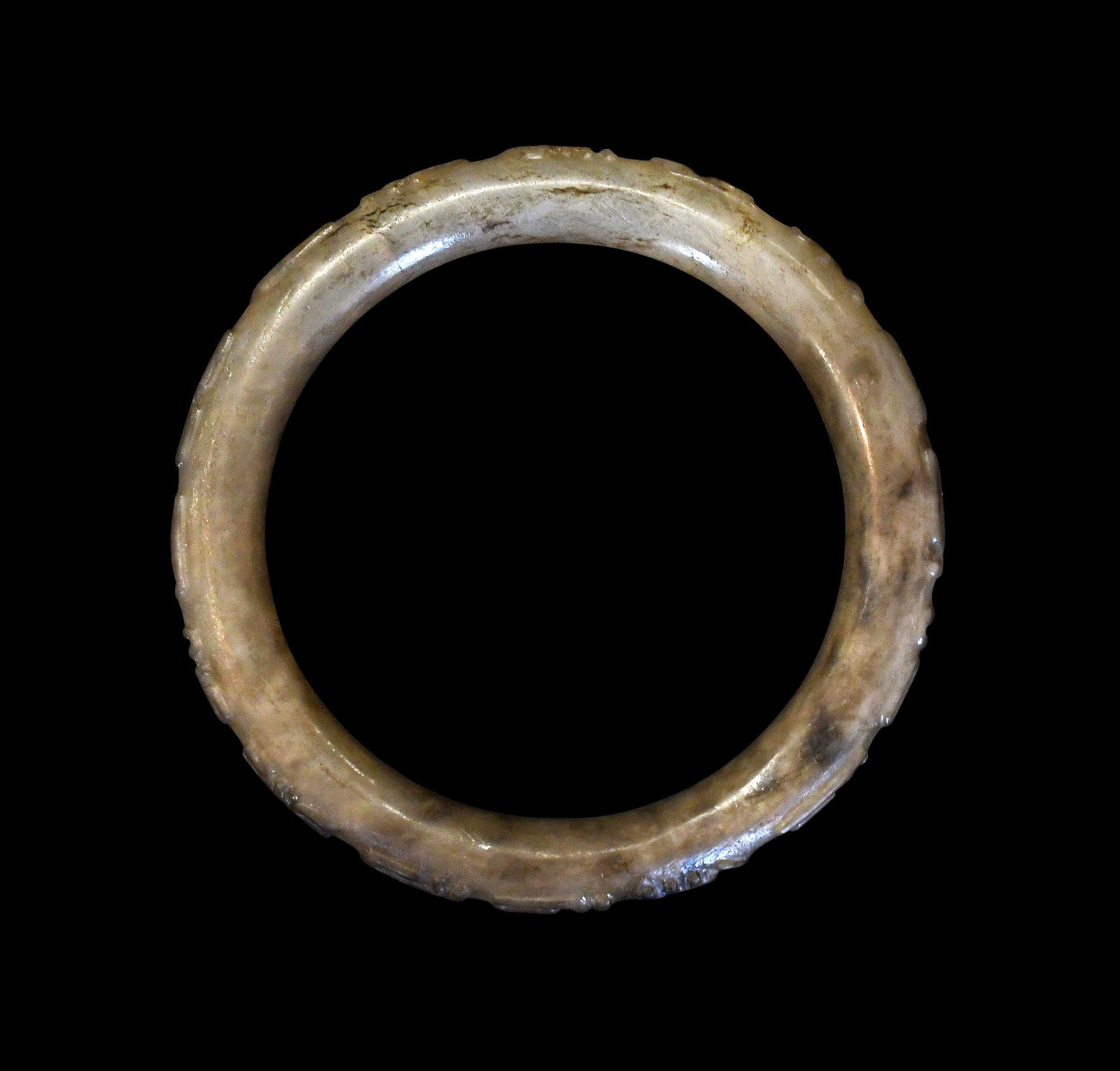 Chinese Carved Jade Archaistic Bangle: mottled celadon jade with black inclusions, 3-1/4 x 3-1/4 x 1/4 in. Provenance: The Collection of William S. Arnett, Atlanta, Georgia; sold to benefit Tinwood Foundation Note: This item tested as