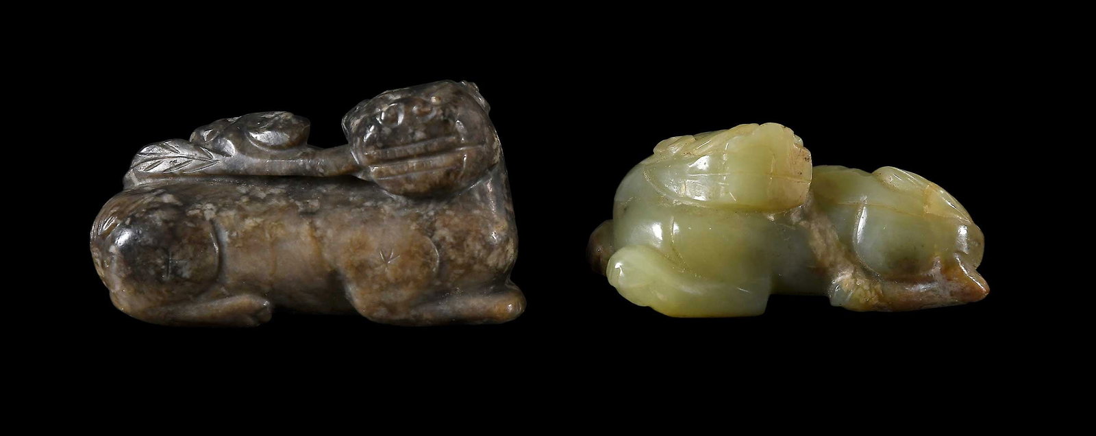 Two Chinese Carved Jade Foo Dogs: one pale green with some russet inclusions and on light gray with dark inclusions, larger 1-1/4 x 2-5/8 x 1 in. Provenance: The Collection of William S. Arnett, Atlanta, Georgia; sold to benefit