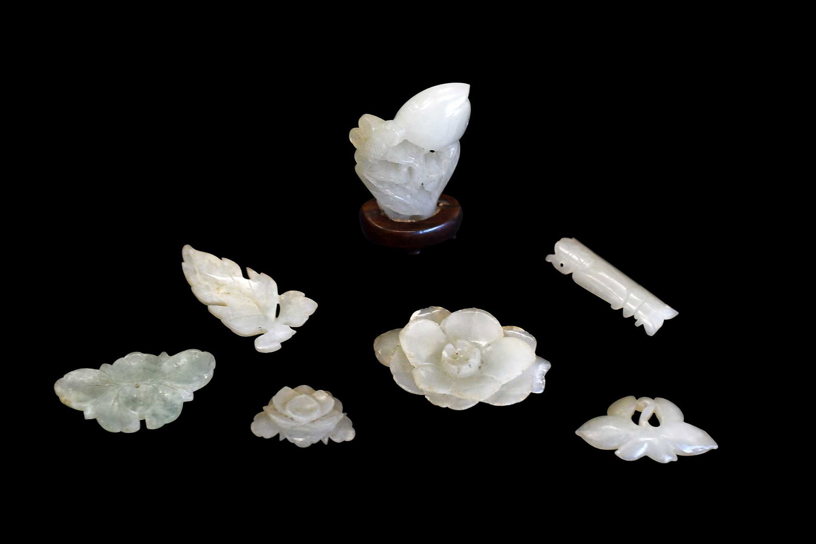 Seven Miniature Chinese Carved Jade Objects: each pale green with some inclusions, one attached to carved wood base, largest 2-3/8 x 1-1/4 x 5/8 in. Provenance: The Collection of William S. Arnett, Atlanta, Georgia; sold to benefit Tinwood