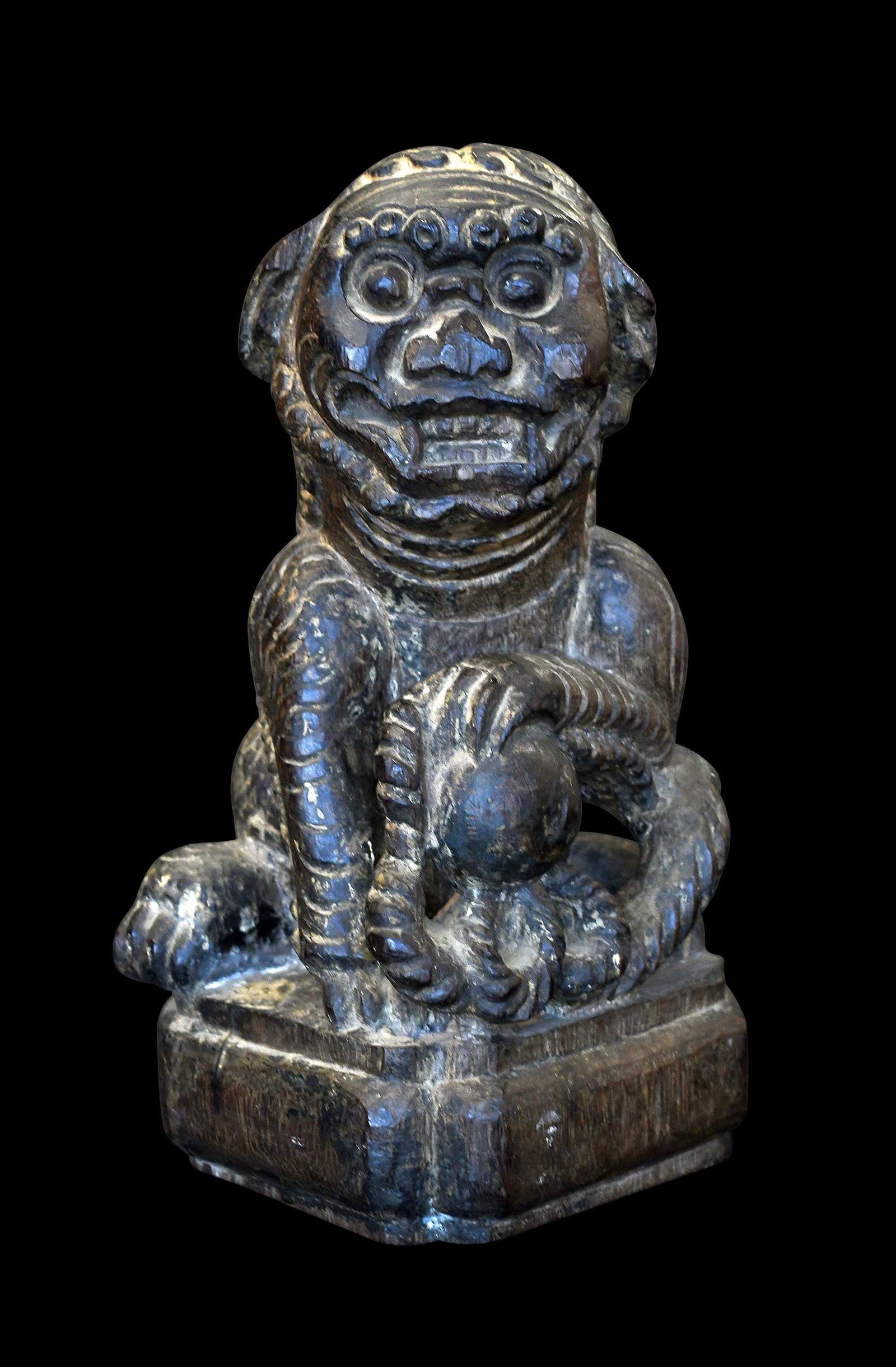 Chinese Qing Carved Wood Seated Guardian Lion or Foo Dog: possibly Ming or early Qing, seated pose with ball and rope, carved base, 13 x 6-3/4 x 5-3/4 in. Provenance: Private Asheville Collection