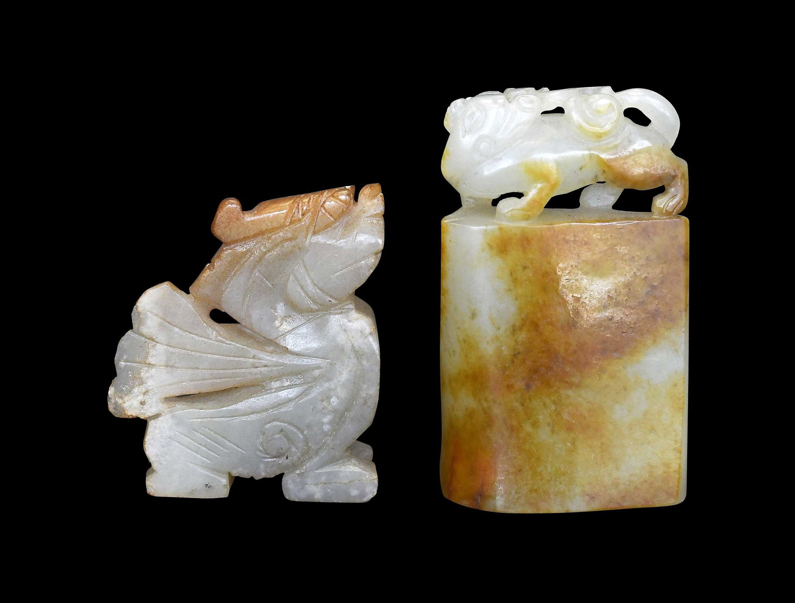 Two Small Chinese Carved Jade Objects: each pale green with russet inclusions, comprising: carved dragon, 1-3/4 x 1-1/2 x 1/2 in.; carved foo dog or dragon on plinth, 2-1/4 x 1-3/8 x 5/8 in. Provenance: The Collection of William S.