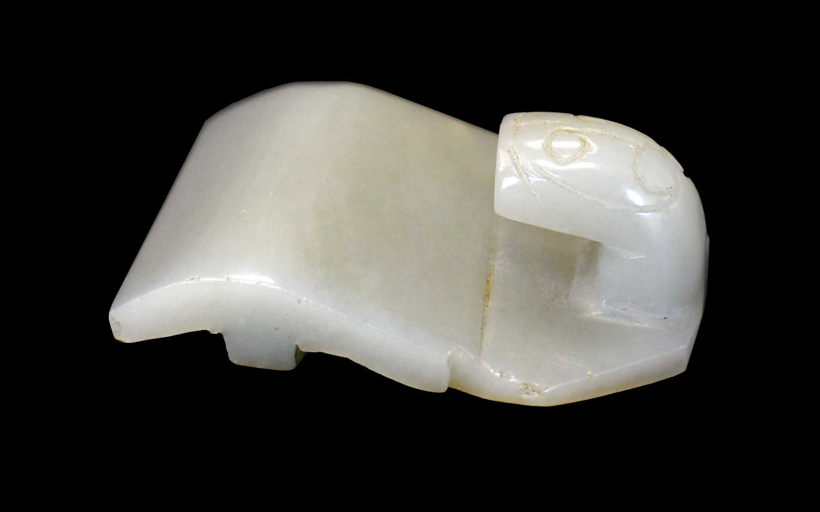 Chinese Carved Jade Belt Hook: simply carved of pale green jade and russet inclusions, 2-1/2 x 1-5/8 x 7/8 in. Provenance: The Collection of William S. Arnett, Atlanta, Georgia; sold to benefit Tinwood Foundation Note: This item te