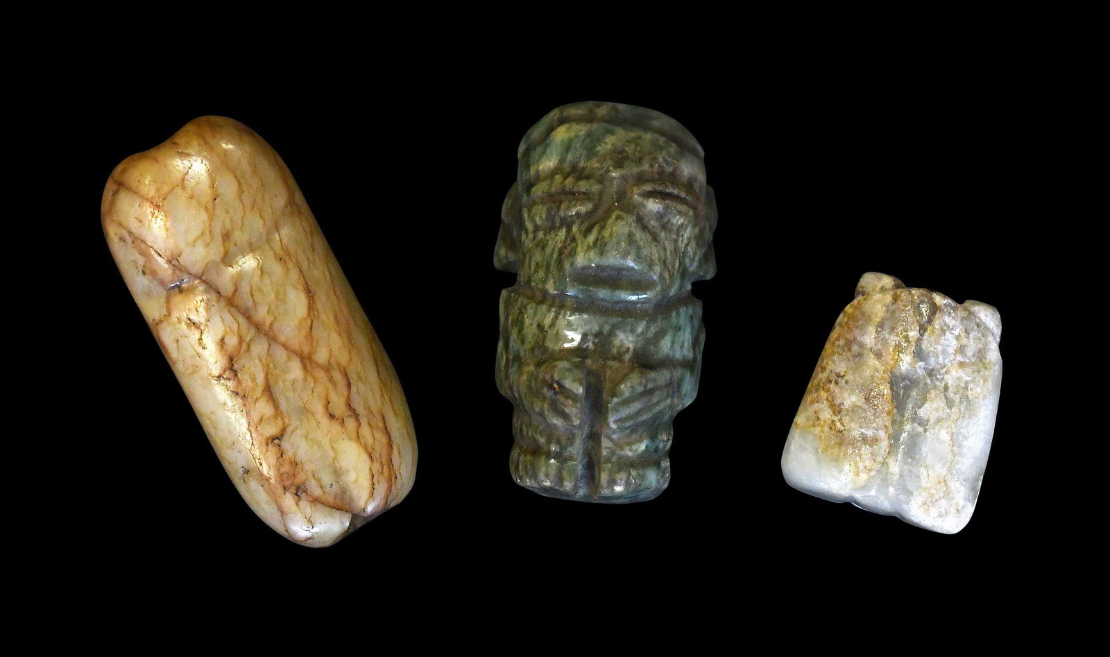 Three Carved Jade Pendants: Mesoamerican or Asian, each with variegated inclusions and engraved decoration, largest 1-3/4 x 1 x 3/4 in. Provenance: The Collection of William S. Arnett, Atlanta, Georgia; sold to benefit Tinwood F