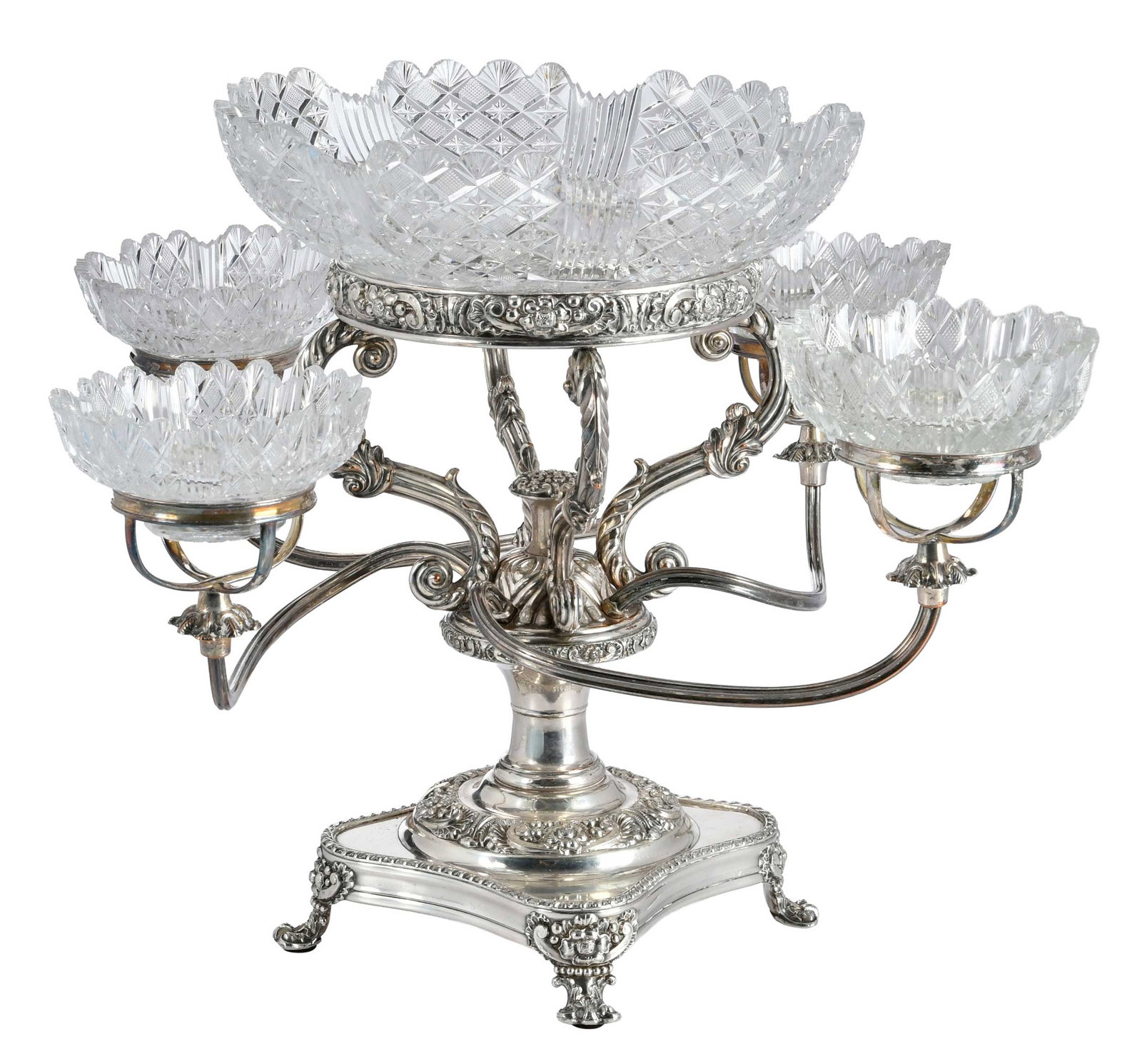 Silver Plate Epergne With Cut Glass Inserts: probably English, late 19th century, floral and scroll decoration, four arm each cut glass bowls, central matching cut glass bowl, unmarked, 13-1/2 x 18-3/4 x 18-3/4 in. Provenance: The Collection of 