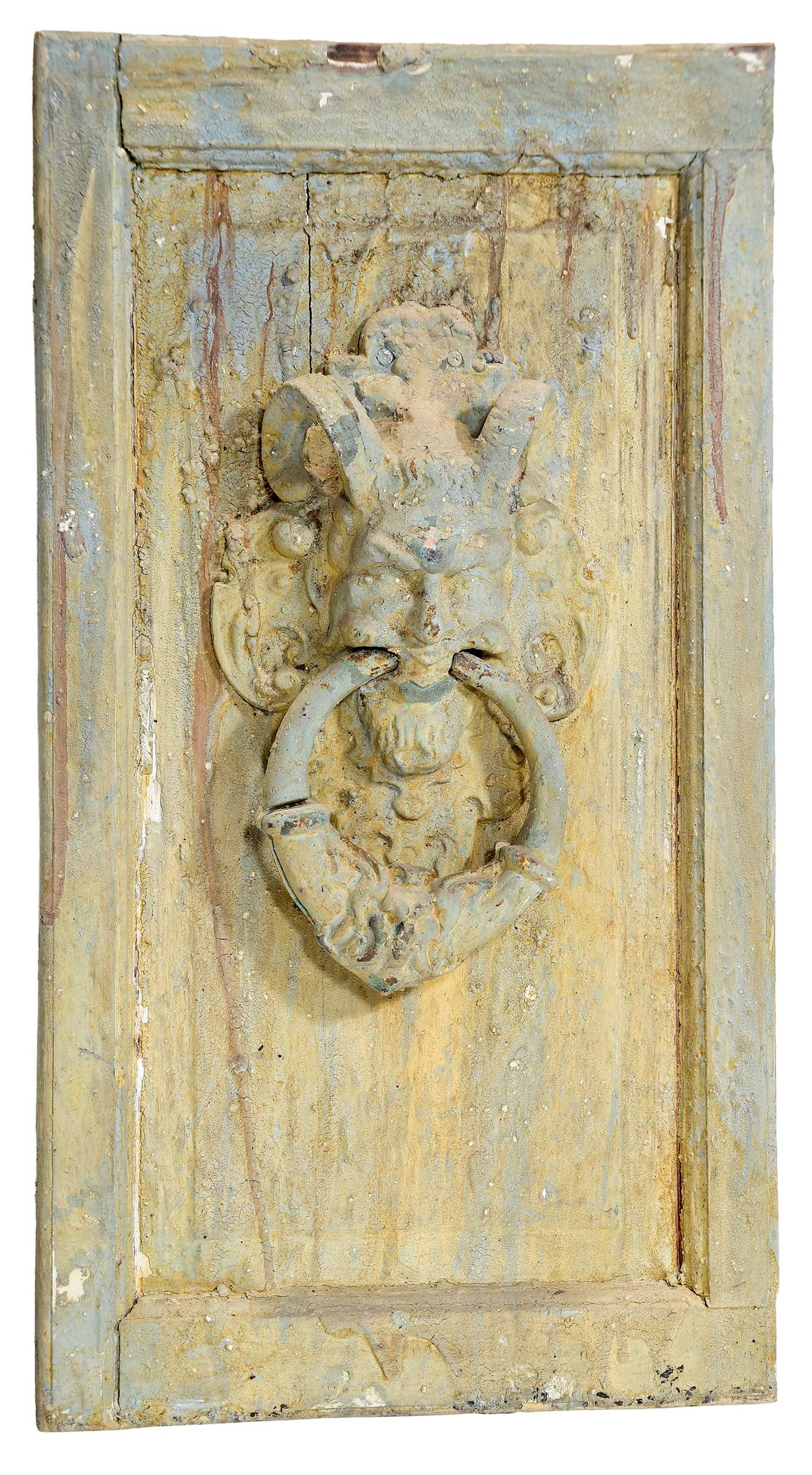 Large Cast Iron Satyr Door Knocker: late 19th/early 20th century, satyr bust with loop knocker, mounted on old wood panel, with weathered blue paint, 28 x 15-1/2 x 4-3/4 in. Provenance: The Collection of Joe Matthews and John Shank,