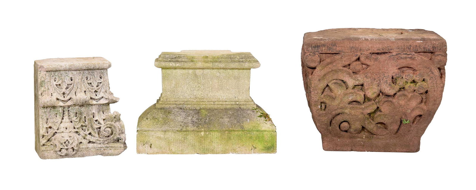 Three Cast and Carved Stone Garden Decorations: late 19th century, plinths or capitals, two cast stone, the largest possibly carved stone, largest with foliate motif, 14 x 16 x 12 in.; another with gothic motif, 11 x 9 x 7 in.; the last with