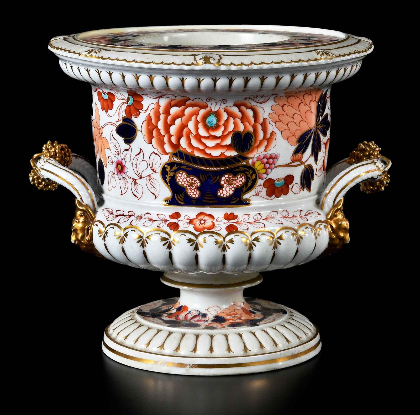 English Imari Pattern Porcelain Wine Cooler: 19th century, unmarked, polychrome and gilt, handles with grape bunch decoration, 9-18 x 10-1/4 x 9-1/4 in. Provenance: The Collection of Joe Matthews and John Shank, Shepherdstown, West Virginia