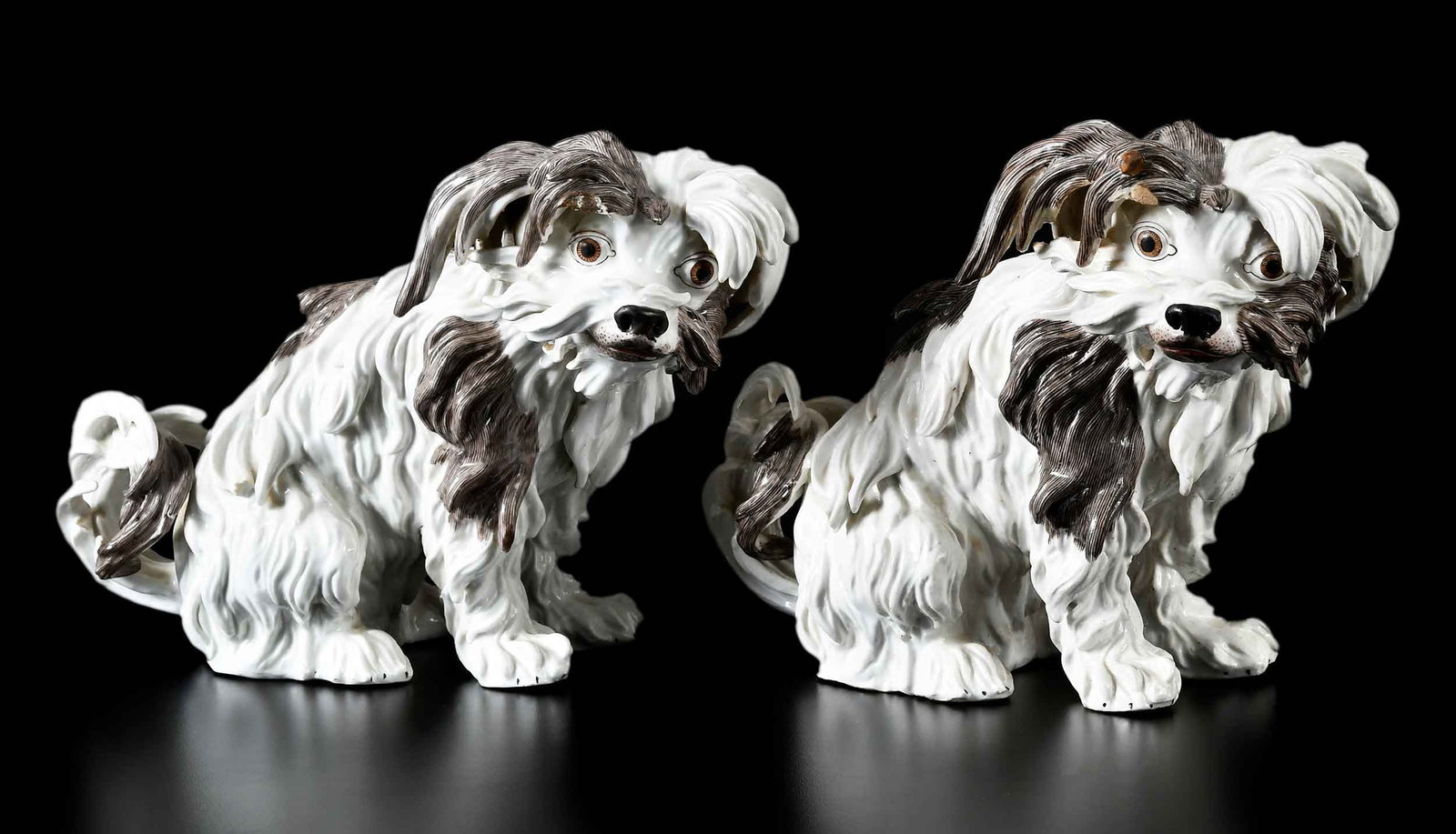 Pair of Meissen or Style Porcelain Bolognese Terriers: late 19th/20th century, each with underglaze blue crossed swords mark at base of tail, expressive painted features, 7-3/4 x 11 x 5 in. Provenance: The Collection of Joe Matthews and John Shank, Shephe