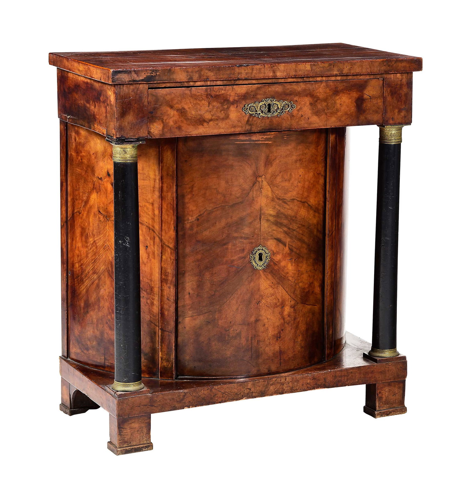 American Classical Style Bookmatched Figured Walnut Parcel Ebonized Cabinet: probably Mid Atlantic or Southern, mid 19th century, one drawer, one door cabinet with shelved interior, ebonized columns, brass or bronze capitals, bases, and mounts to door and drawer, pine secondar