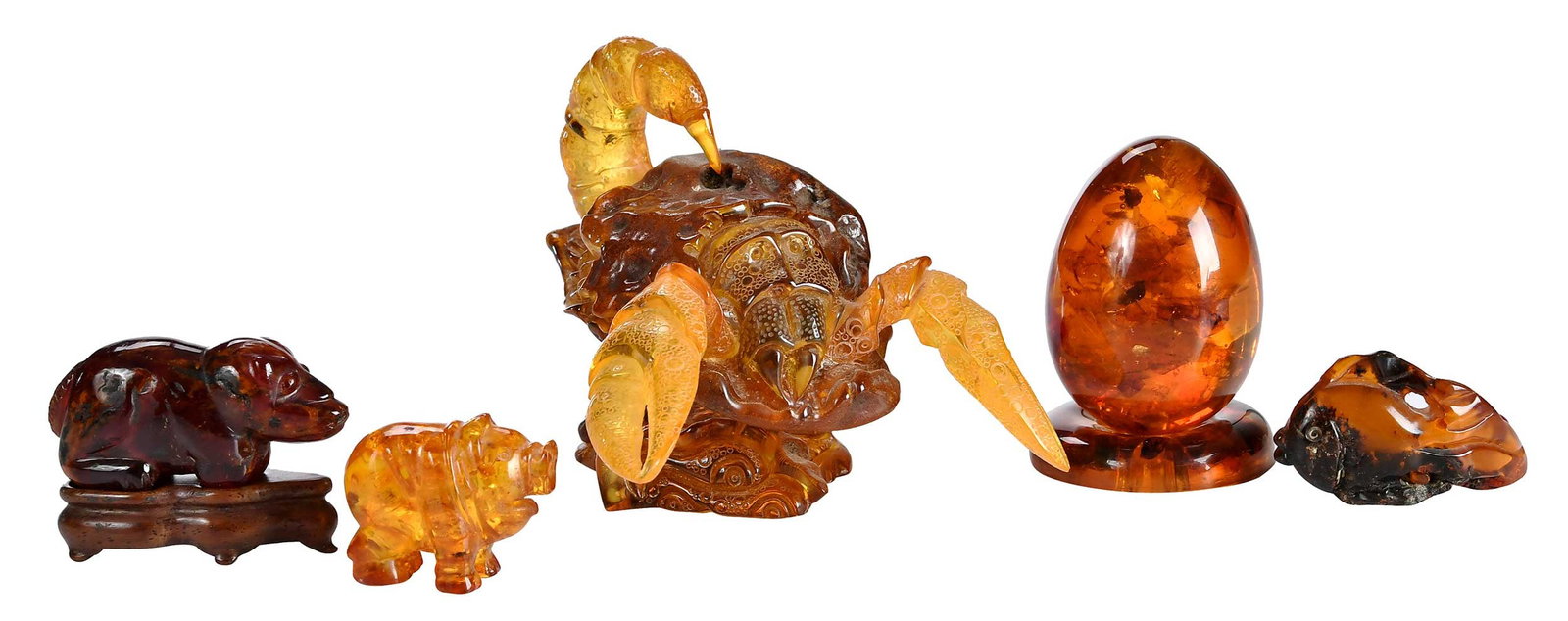 Five Carved Amber Figural Table Objects: comprising: scorpion; egg with base; fish; pig; four legged animal with wood base; largest 3-1/4 x 3-3/4 x 5 in. Provenance: The Collection of Joe Matthews and John Shank, Shepherdstown, West Virginia