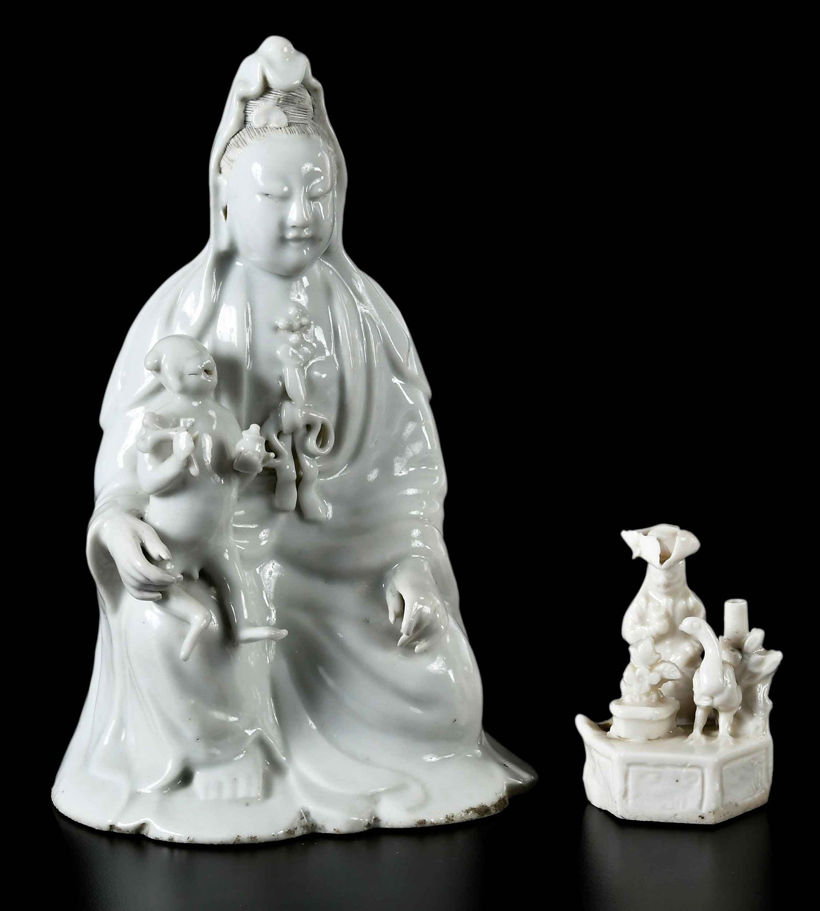 Two Chinese Dehua Porcelain Figural Groups: late Qing dynasty, seated Guanyin with child; European figural group; larger 8 x 5 x 4 in. Provenance: The Collection of Joe Matthews and John Shank, Shepherdstown, West Virginia