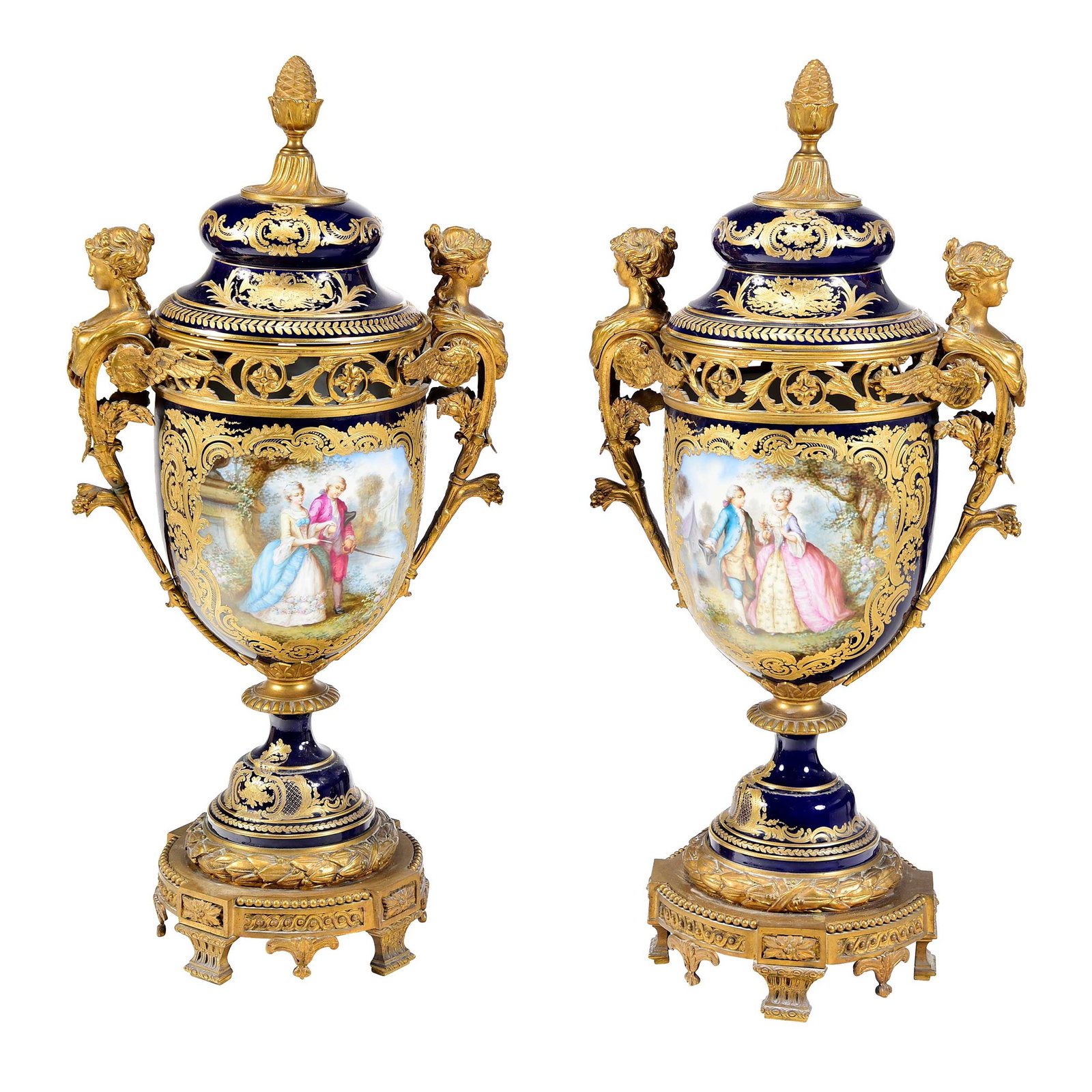 Pair of Large Sevres or Style Cobalt and Gilt Porcelain Urns with Bronze Mounts: French, late 19th/early 20th century, Sevres marks at lid interiors, hand painted cartouches featuring landscapes and figural scenes, each approx. 29 x 14-1/2 x 8-1/2 in. Provenance: A Private Florida